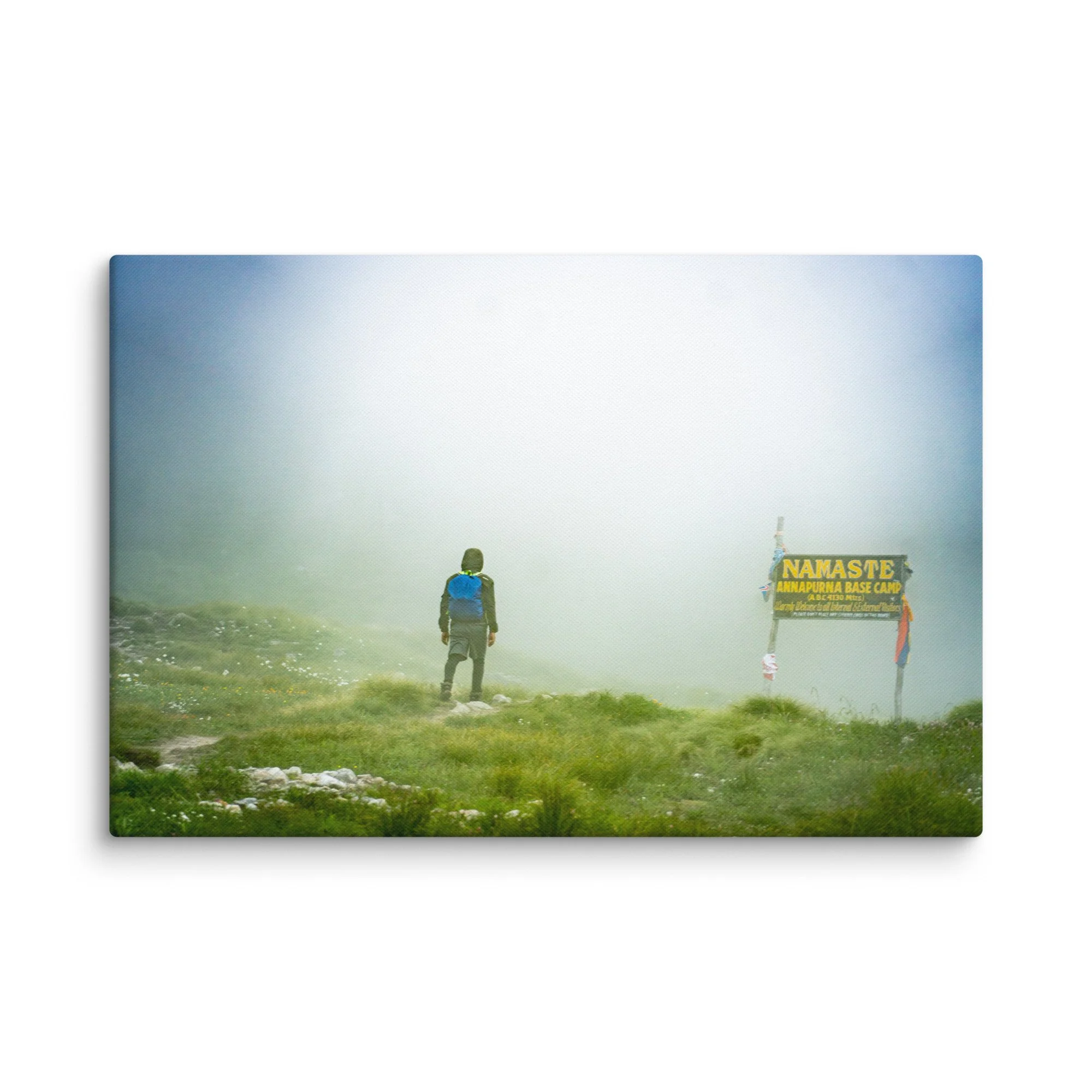 Trekker standing at the famous Namaste Annapurna Base Camp signpost in misty alpine terrain, Nepal – high-altitude trekking travel photography canvas print wall art decor