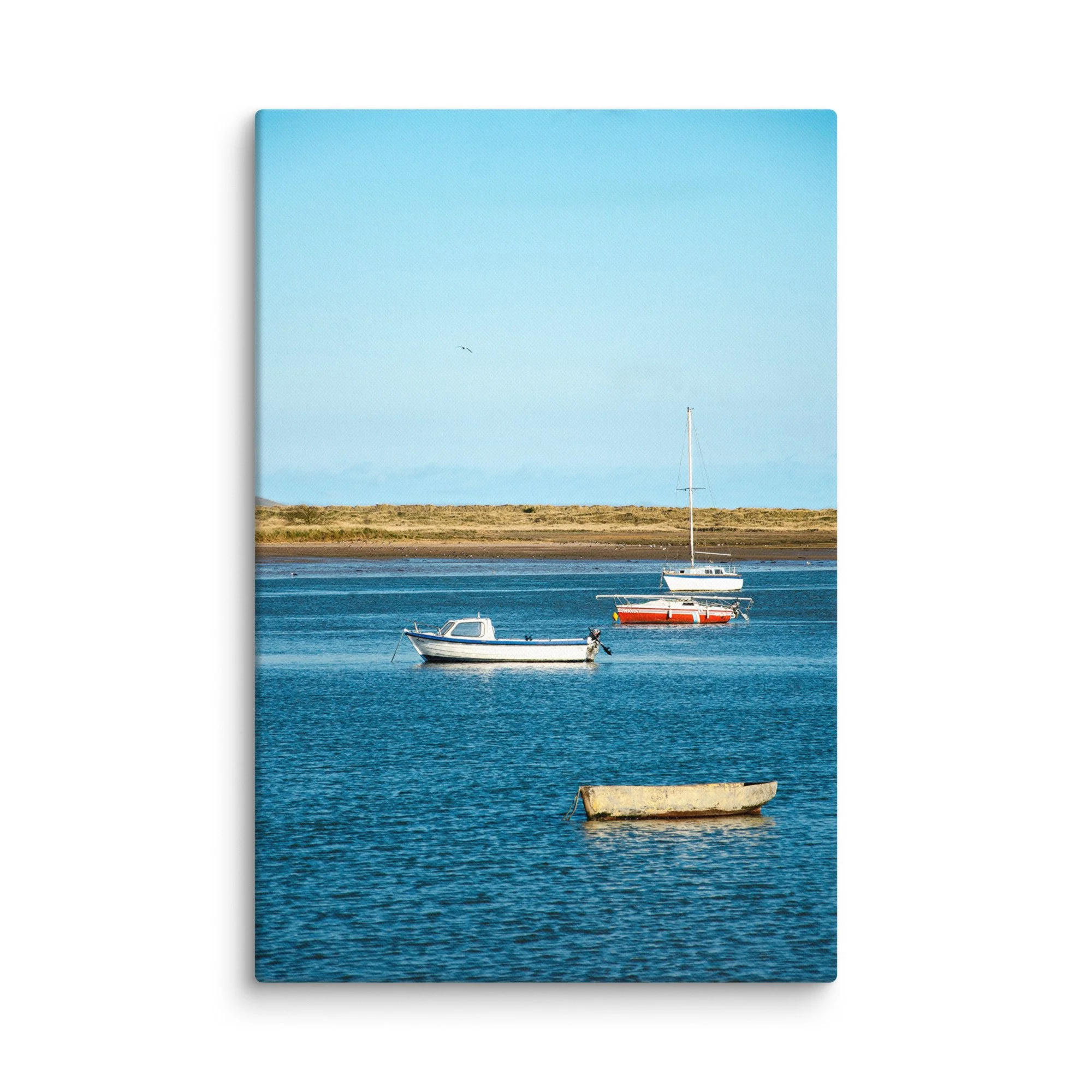 Traditional fishing boats moored in calm blue tidal waters with golden marram grass dunes and distant hills, Ireland – coastal travel photography canvas print wall art decor