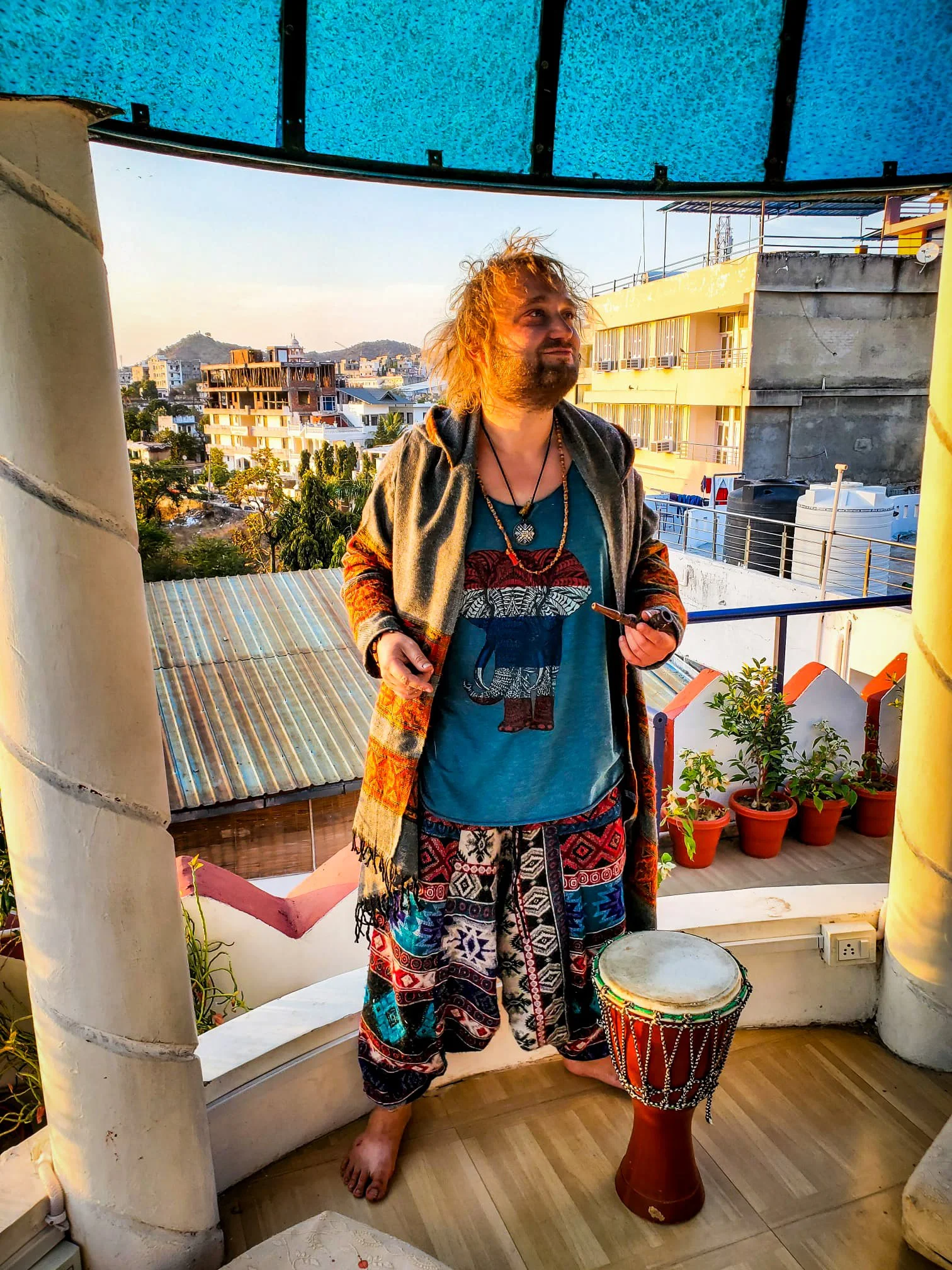 artist Jadoo with drums standing on roof in India