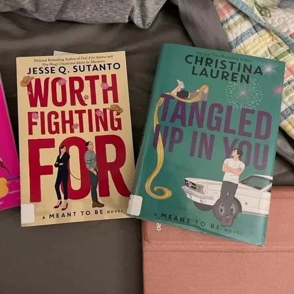 Two library books are shown "Worth Fighting For" by Jesse Q. Sutanto + "Tangled Up in You" by Christina Lauren of the Meant to Be series -- books based on some of our fav Disney princesses but in the modern, real world