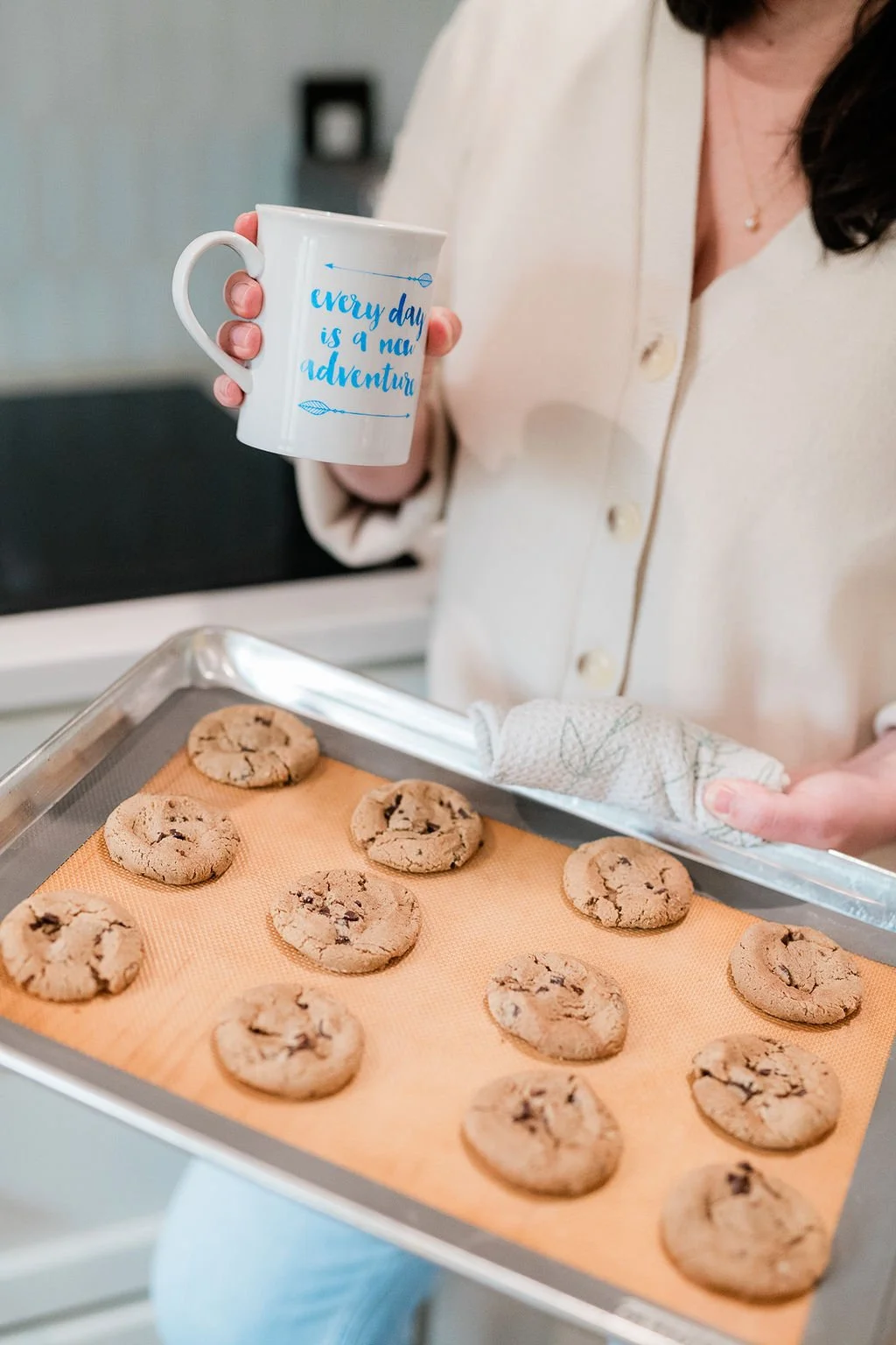 Angela holds a tray of gluten-free chocolate chip cookies right out of the oven representing her love of baking. Imagine how good those smell!