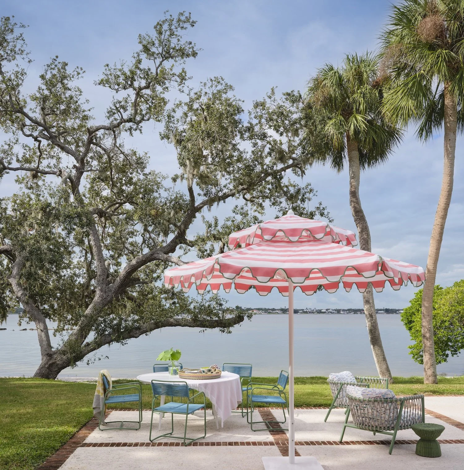 56-outdoor-patio-dining-pink-striped-umbrella-waterfront-florida-living-palm-trees-stylish-outdoor-space.jpg
