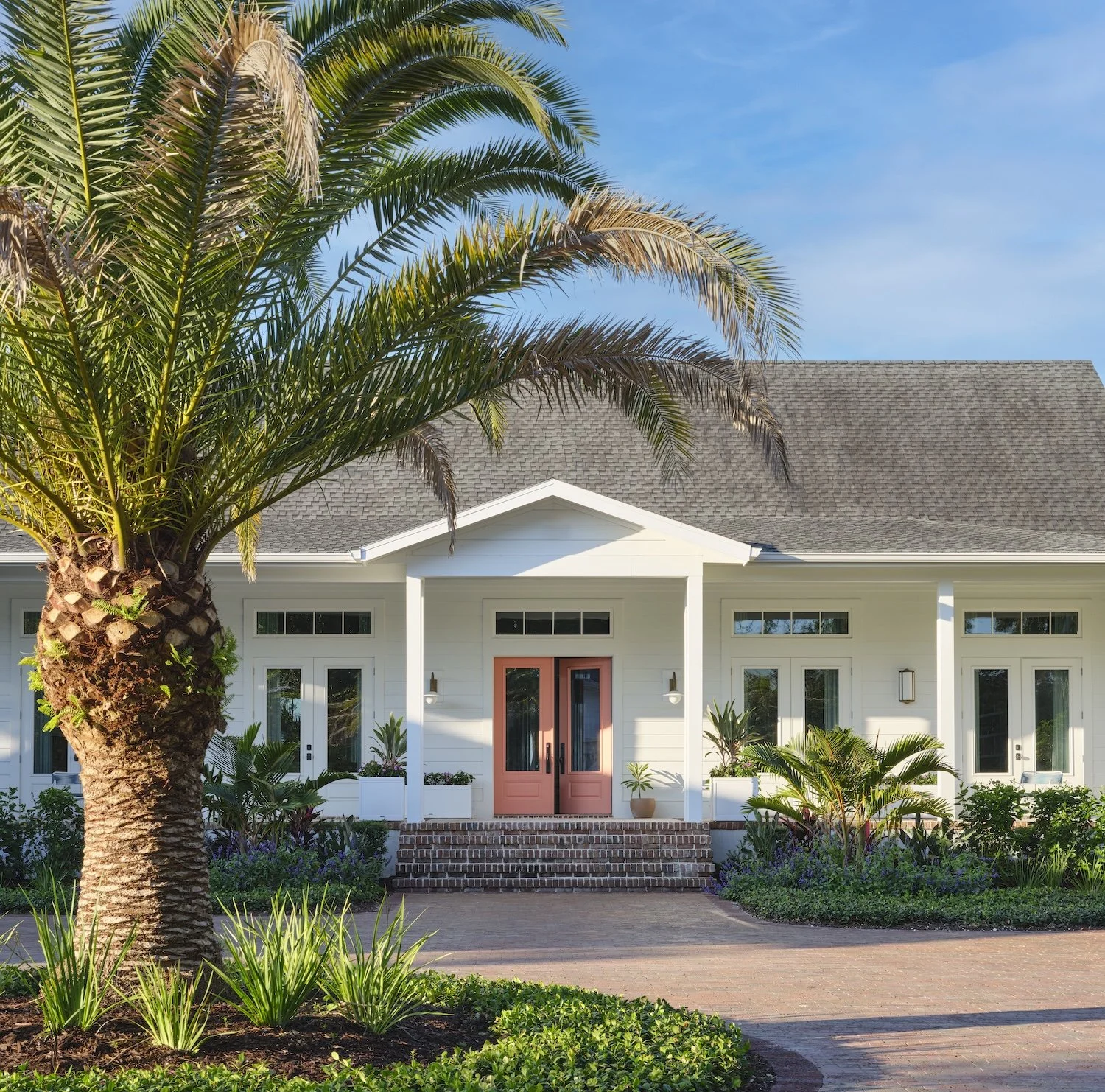 3-florida-home-front-entrance-pink-door-tropical-landscaping-palm-tree-lush-design-curb-appeal-modern-paradise.jpg