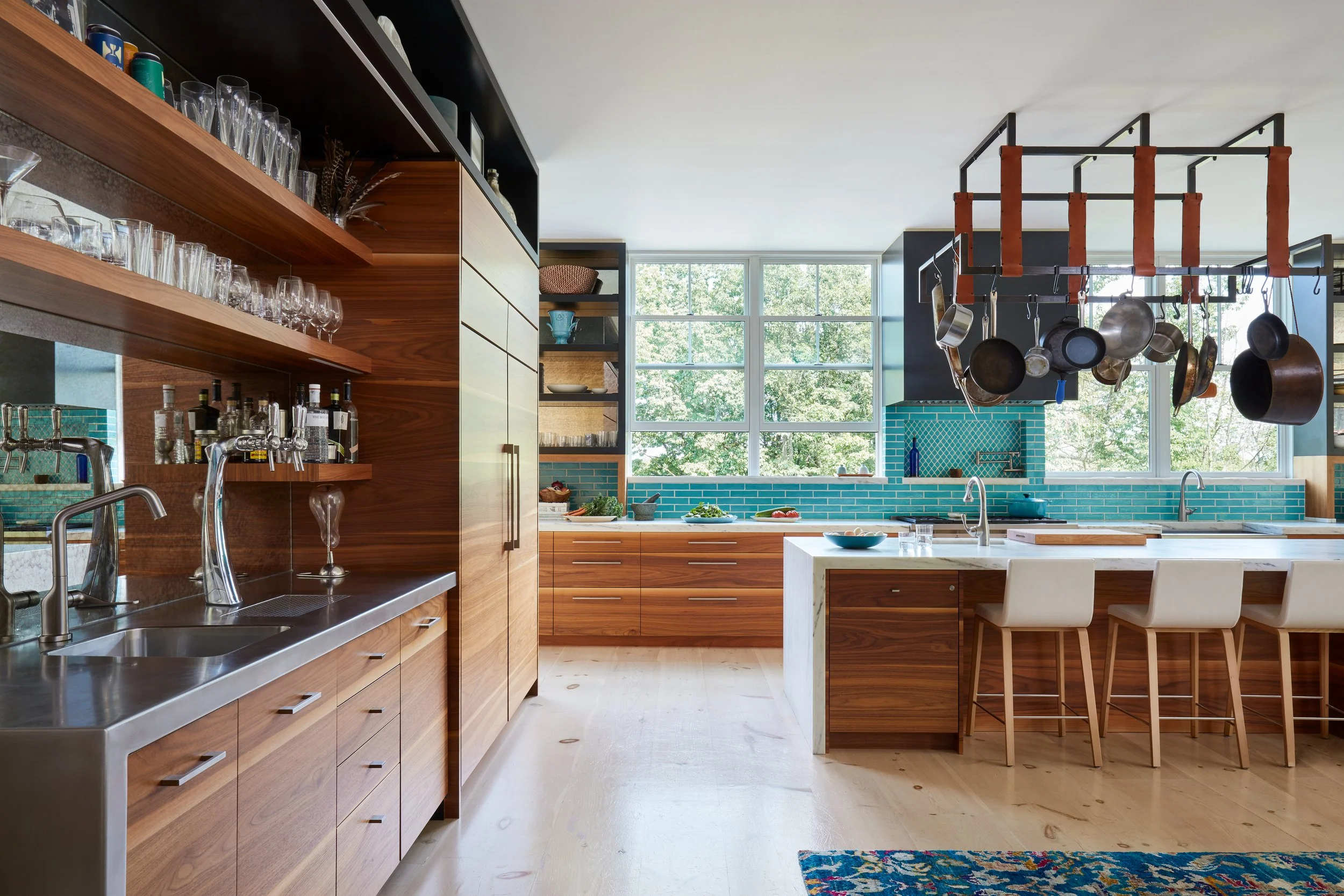 modern-mid-century-kitchen-design-with-warm-wood-cabinets-and-teal-back-splash-featuring-an-island-with-white-countertop-and-bar-stools-plus-open-shelf-styling-and-suspended-pot-rack-for-inspired-interior-design-ideas.jpg