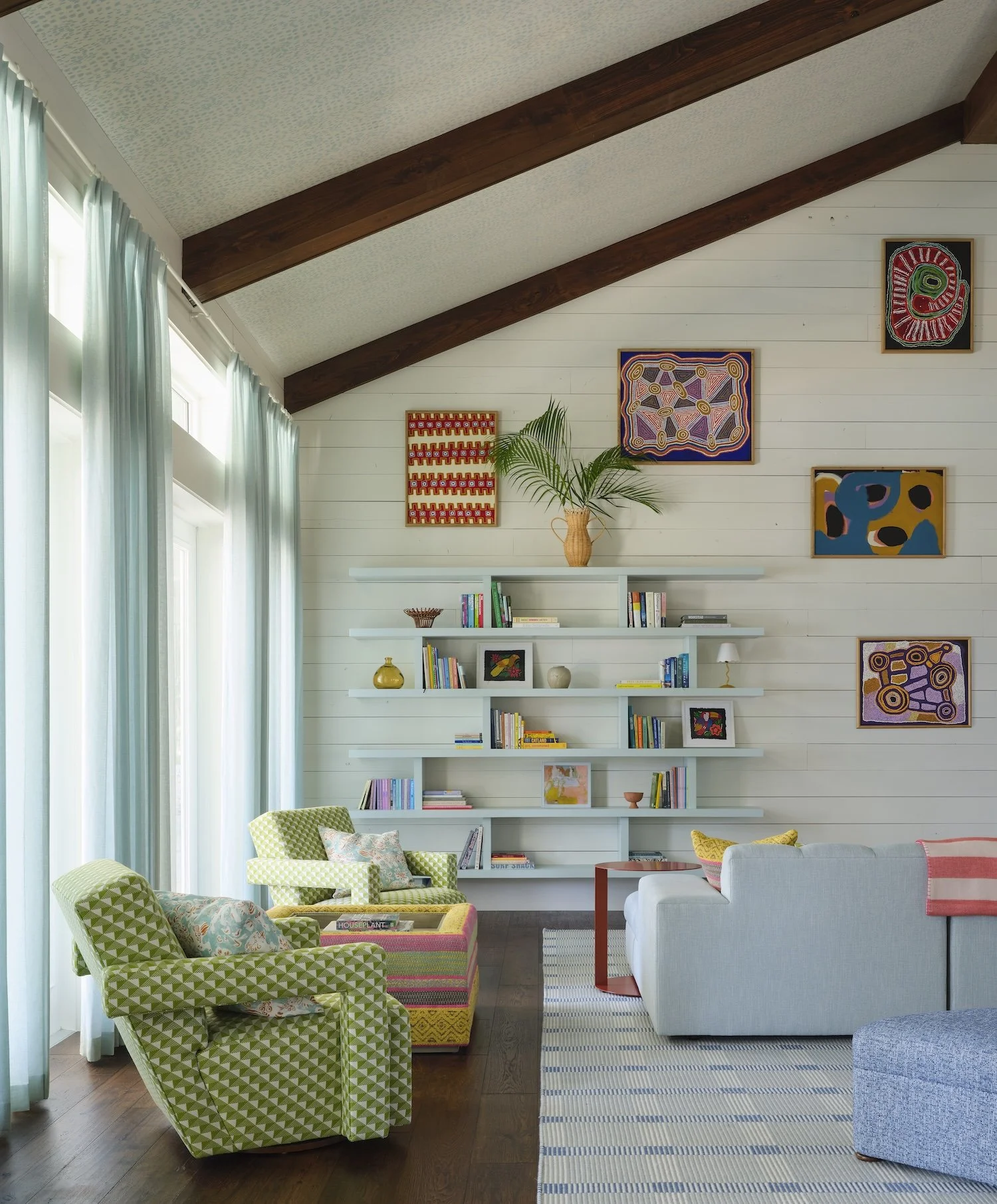 11-florida-home-vaulted-ceiling-exposed-beams-colorful-art-geometric-chairs-blue-shelving-vibrant-coastal-design.jpg