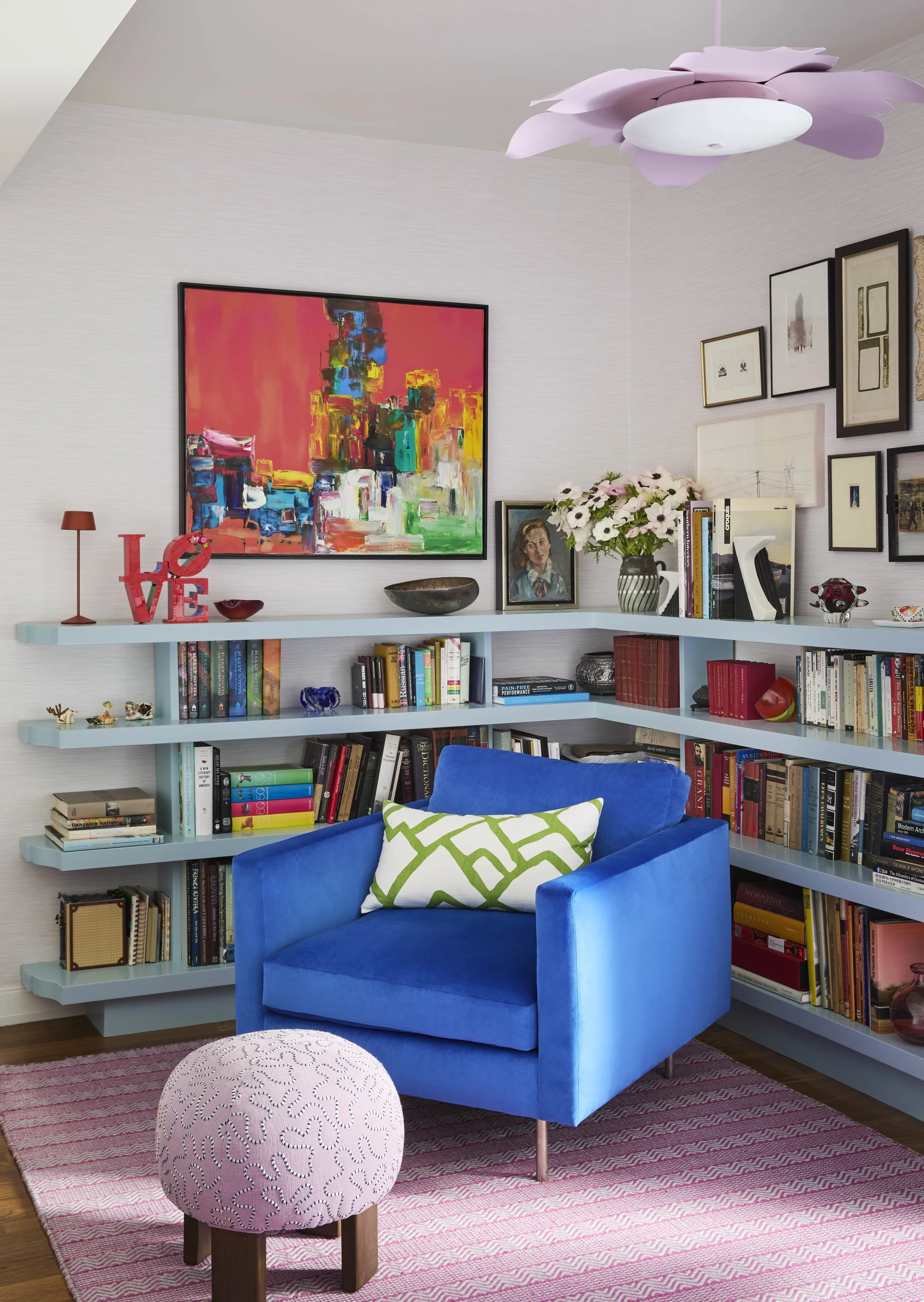 Blue accent chair with custom blue shelving styled with books. 