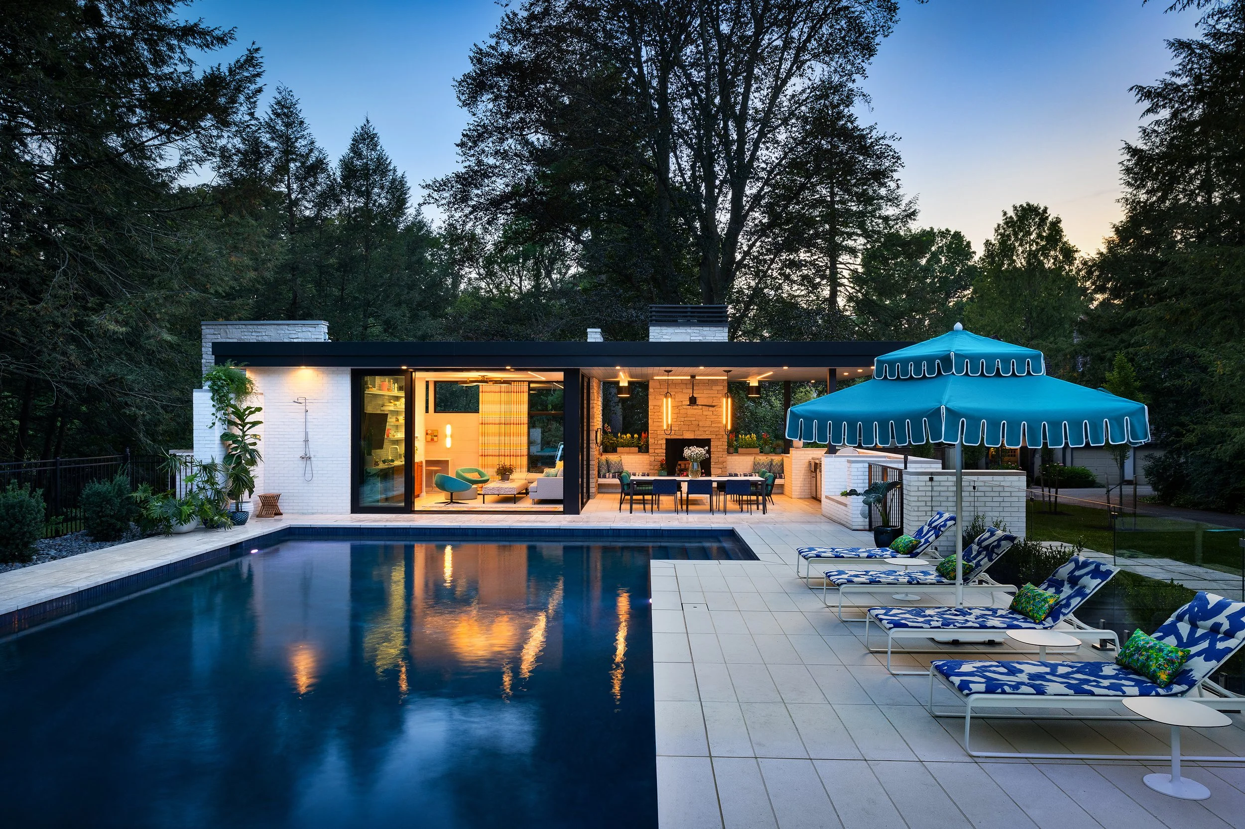 pool and pool house design with lounge chairs and umbrellas 
