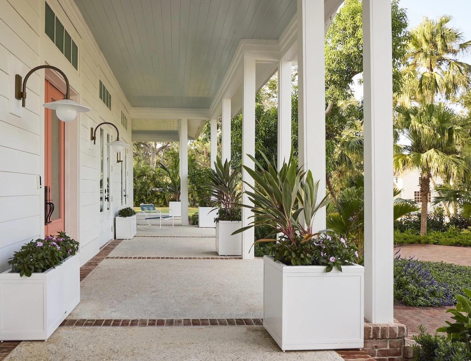 4-florida-home-porch-design-white-columns-planters-pink-door-blue-ceiling-tropical-outdoor-living-space.jpg