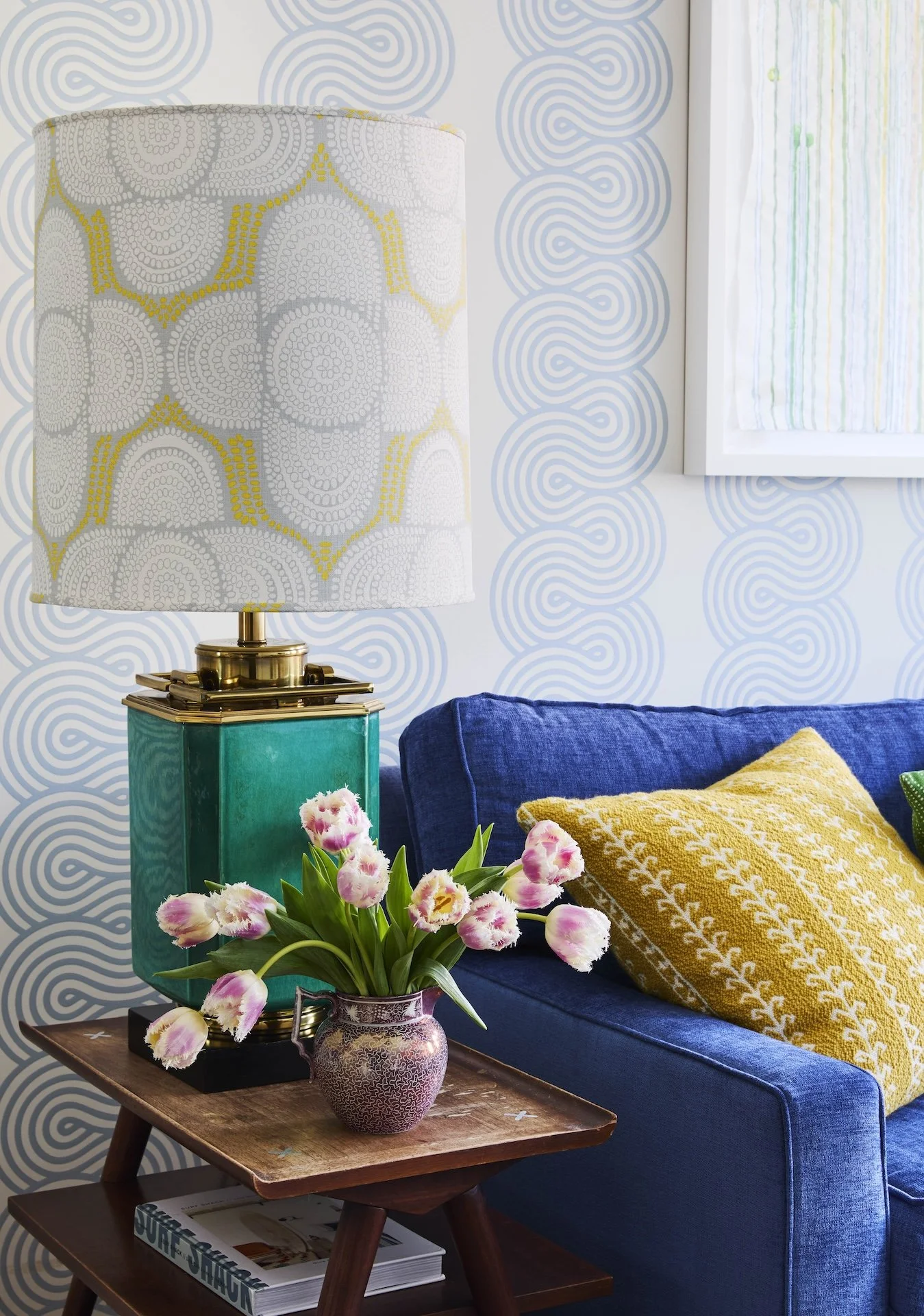 colorful modern living room blue sofa yellow pillow patterned wallpaper stylish lamp wood side table