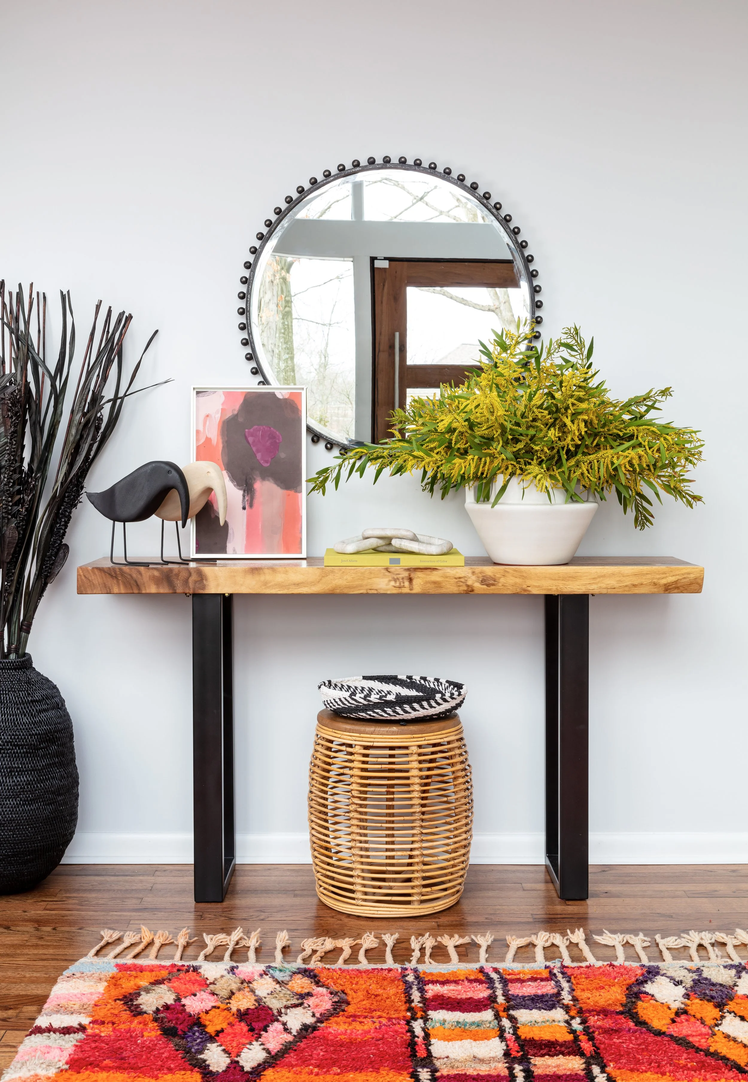 modern-home-entry-with-live-edge-console-mirror-and-bright-colorful-rug.jpeg