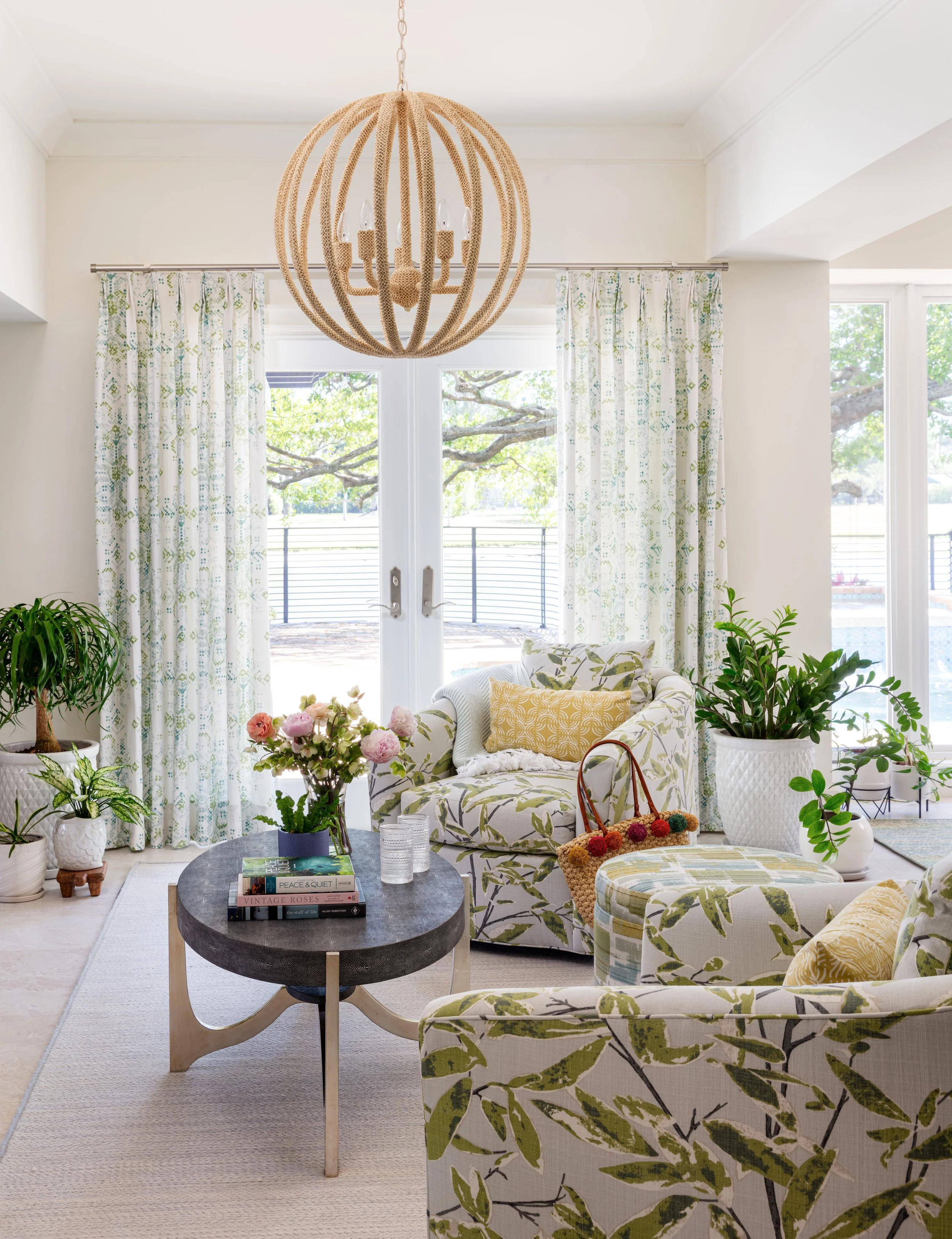 bright-and-airy-living-space-featuring-modern-coastal-interior-design-with-floral-armchairs-rattan-chandelier-and-oval-coffee-table.jpg