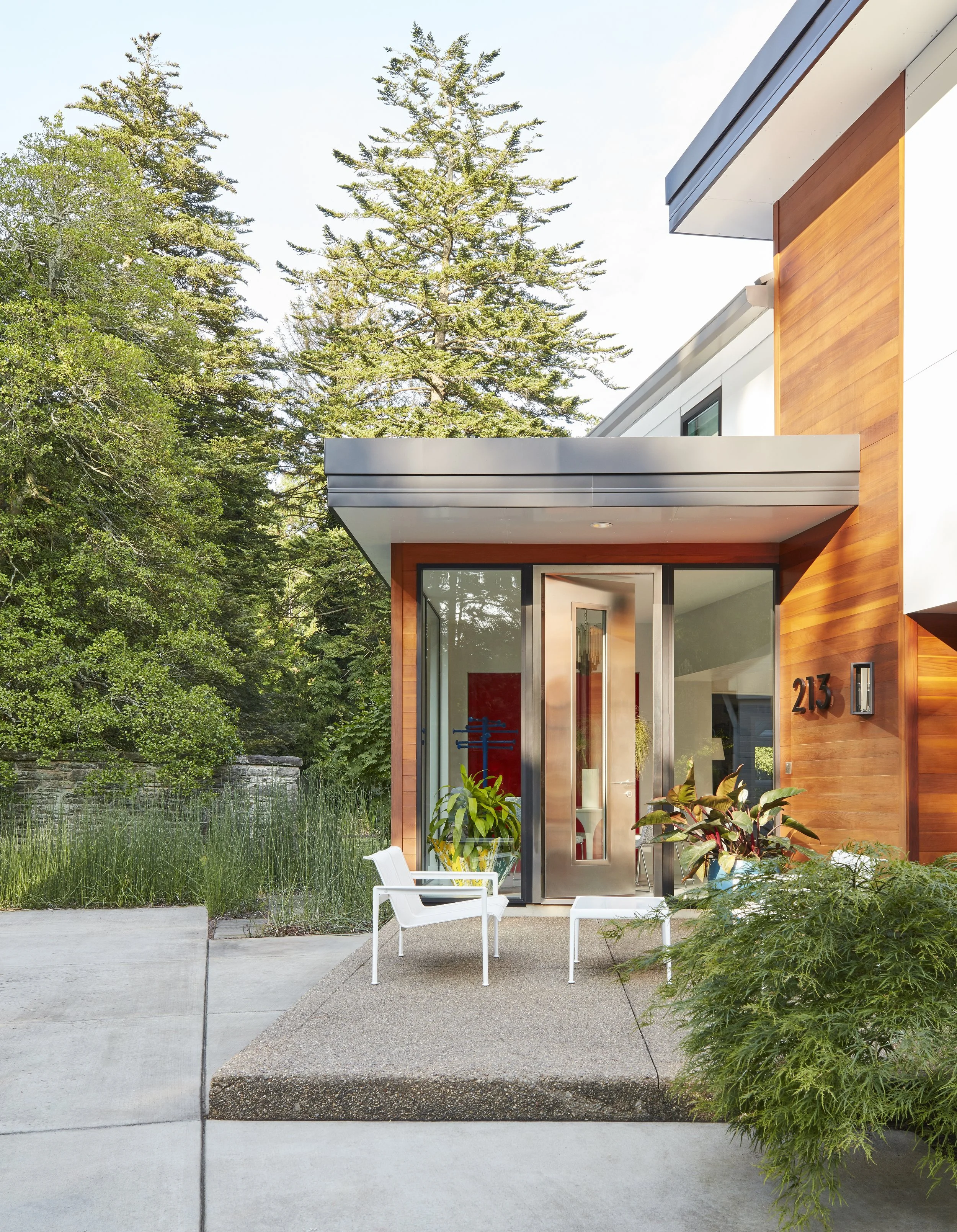 modern home front entry with glass doors and outdoor seating