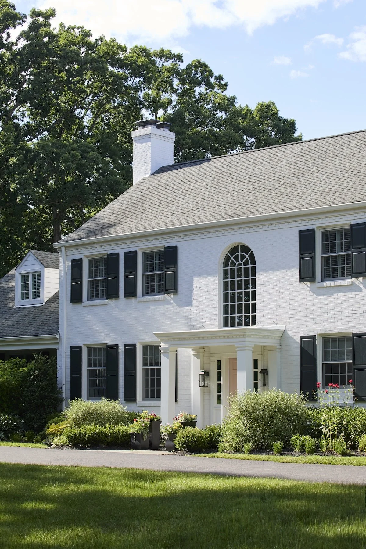 Pittsburgh colonial with black shutters tall arched window blush front door 
