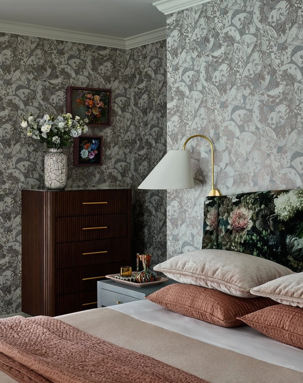 bedroom fan wallpaper floral headboard brass sconce reeded dresser blush bedding and curated art displays