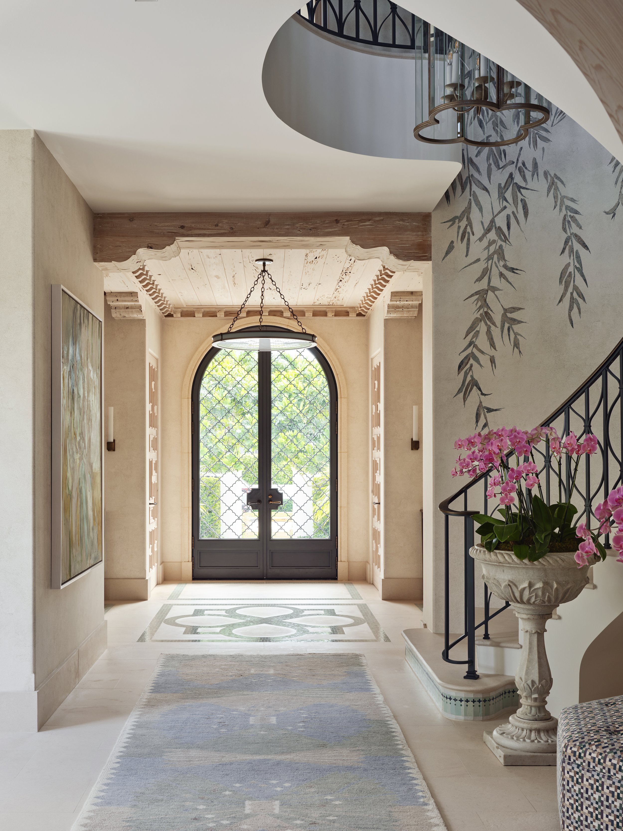 entryway mediterranean style arched door staircase orchid beige walls rug artwork modern ambiance