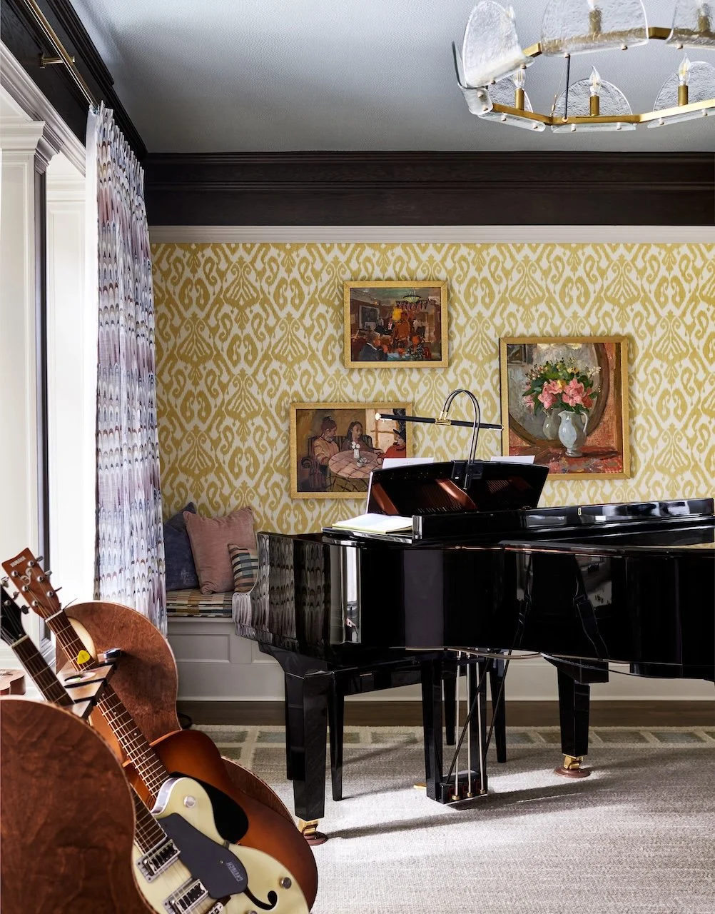 Eclectic music room grand piano ikat wallpaper gallery art window seat brass chandelier 