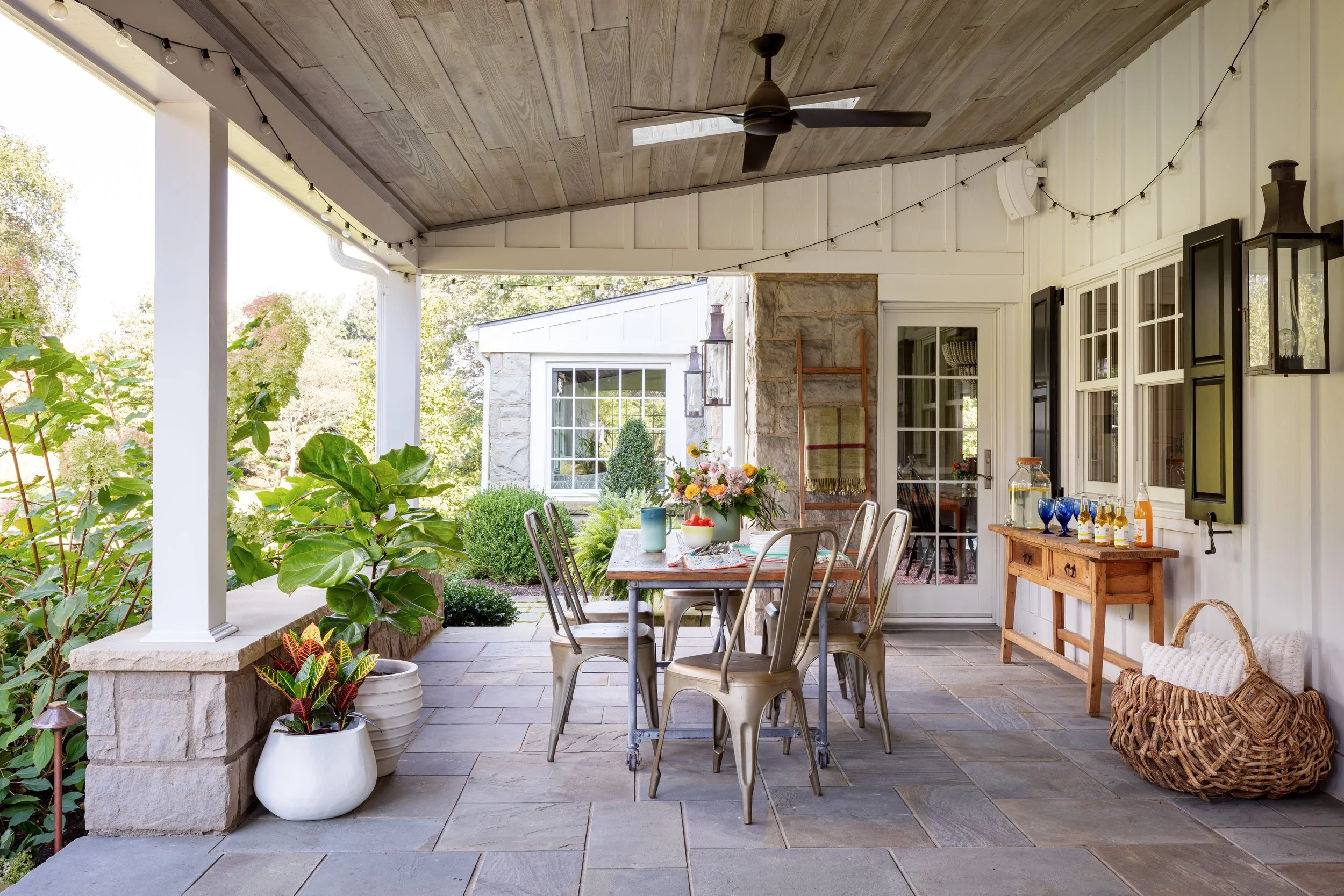 Elegant outdoor patio design with rustic wooden ceiling, dining set, string lights & lush greenery for stylish alfresco entertaining spaces modern home décor