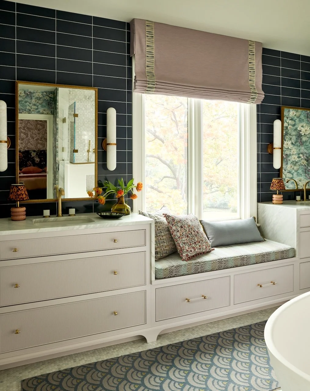 Navy tile bathroom reeded dual vanities brass sconces marble tops window seat trimmed roman shade patterned floor tile