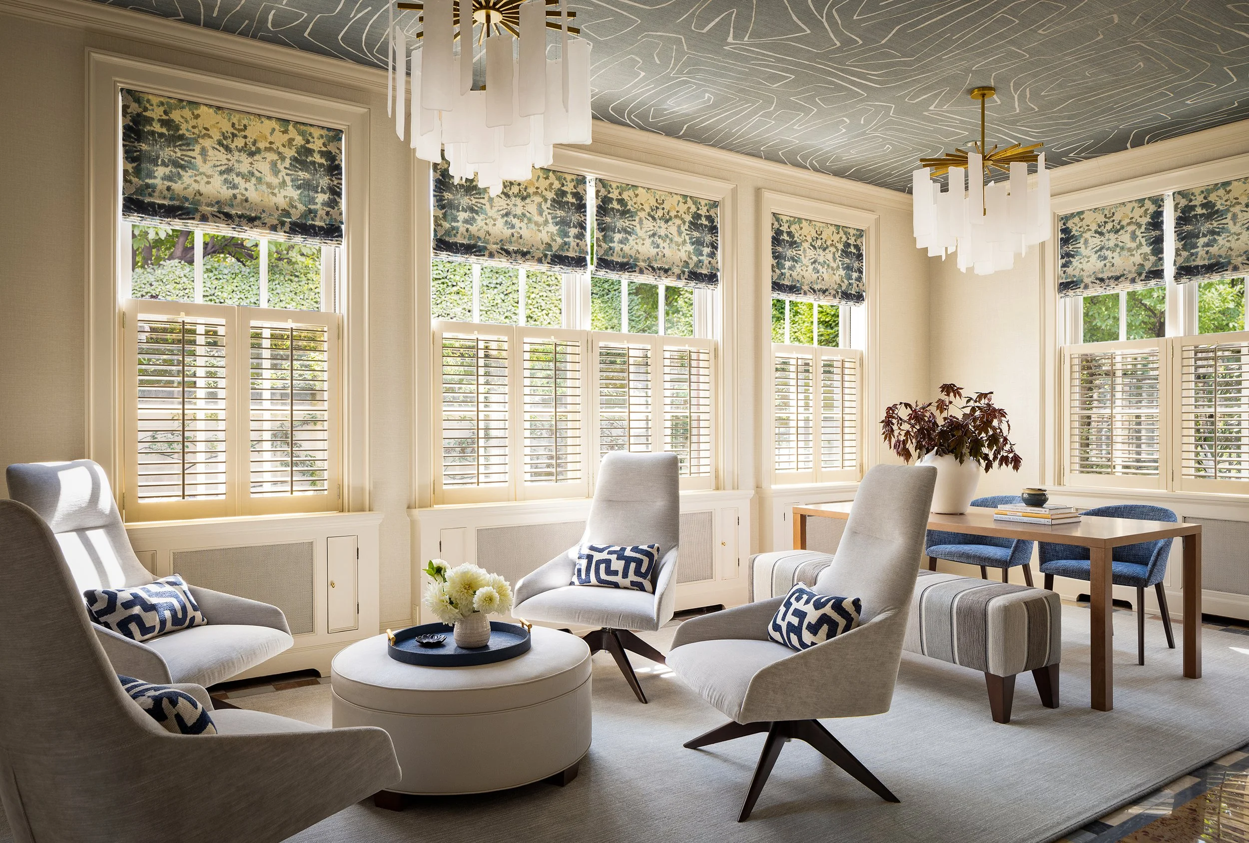 inviting conversation area with four neutral lounge chairs around an ottoman and crystal chandelier above
