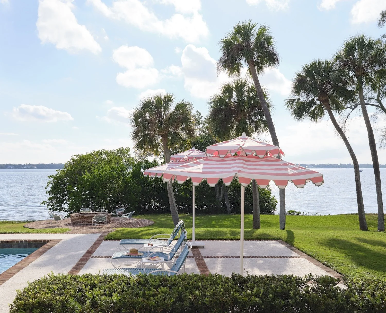 57-poolside-lounge-florida-waterfront-pink-umbrellas-palm-trees-firepit-luxurious-outdoor-living-design.jpg