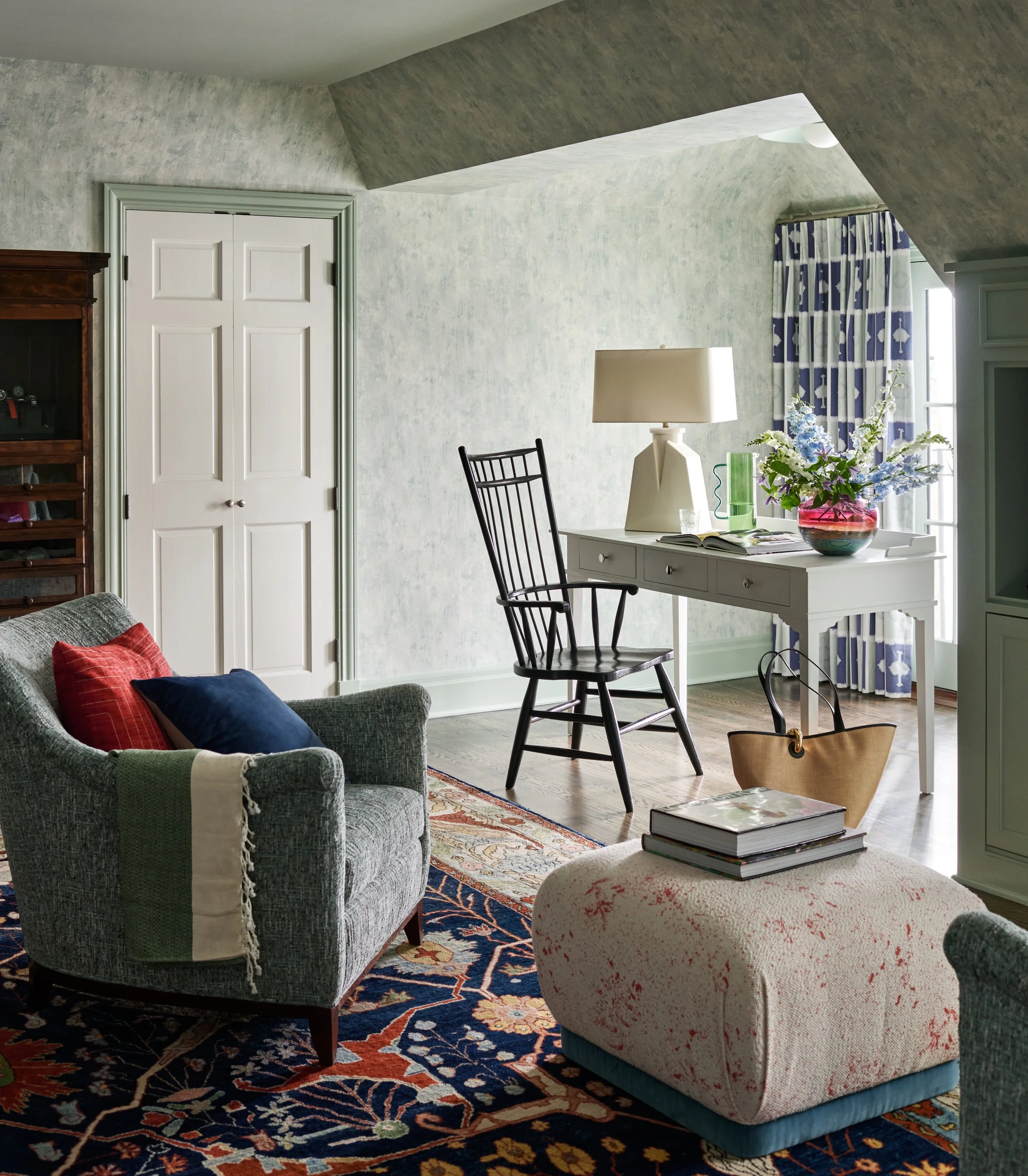 Seating area in bedroom by window with desk and chair. 
