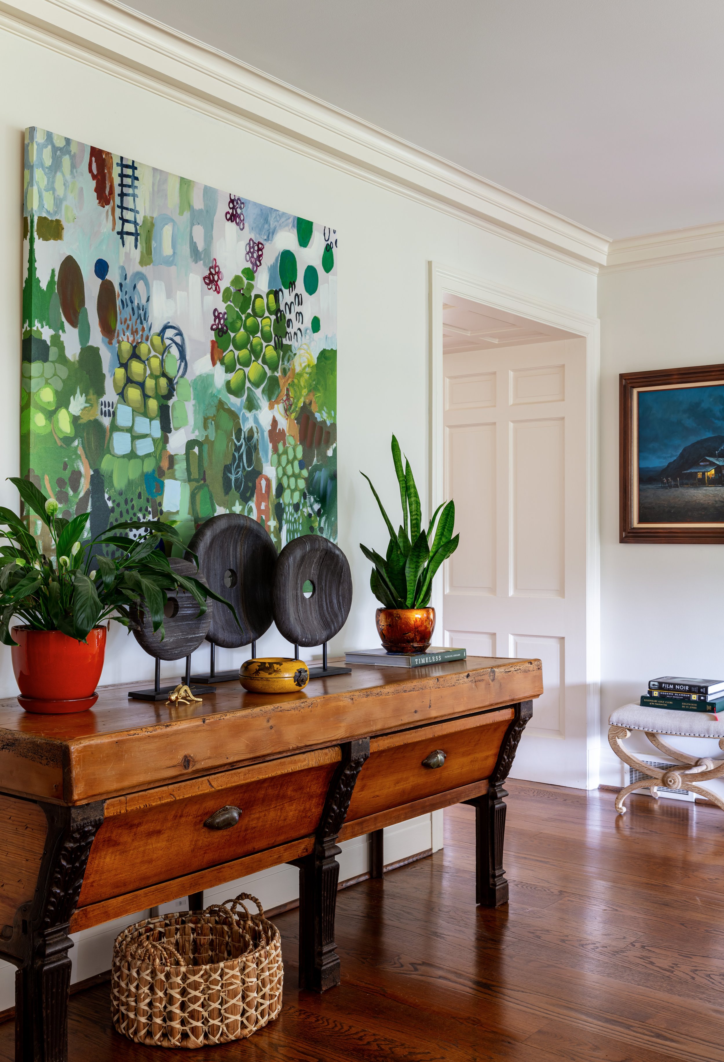 hallway with antique console table rustic sculpture accessories and colorful art abve for farmhouse decor design