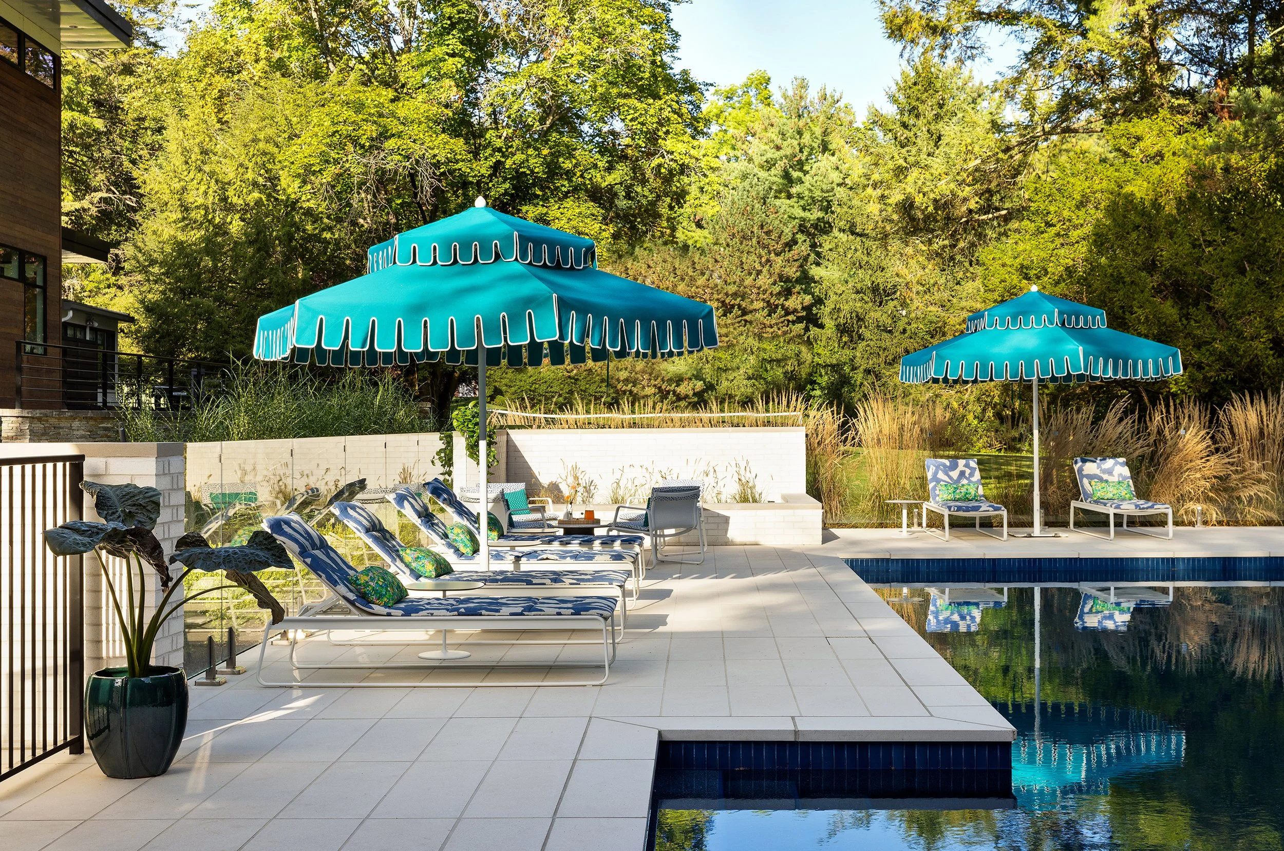 fun pool design with teal umbrellas lounge chairs