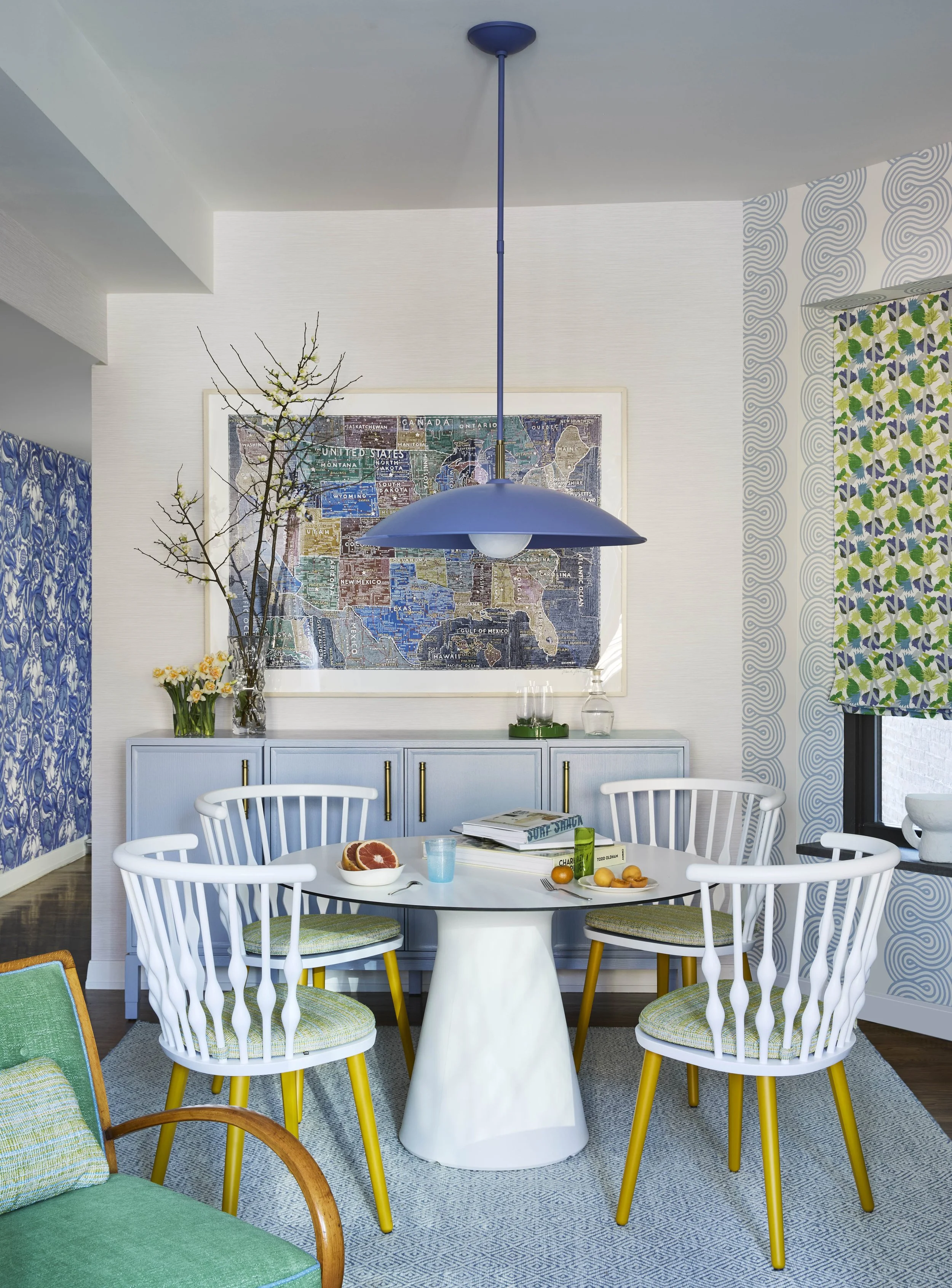 Dining table and chairs with white spindle, blue pendant light. 