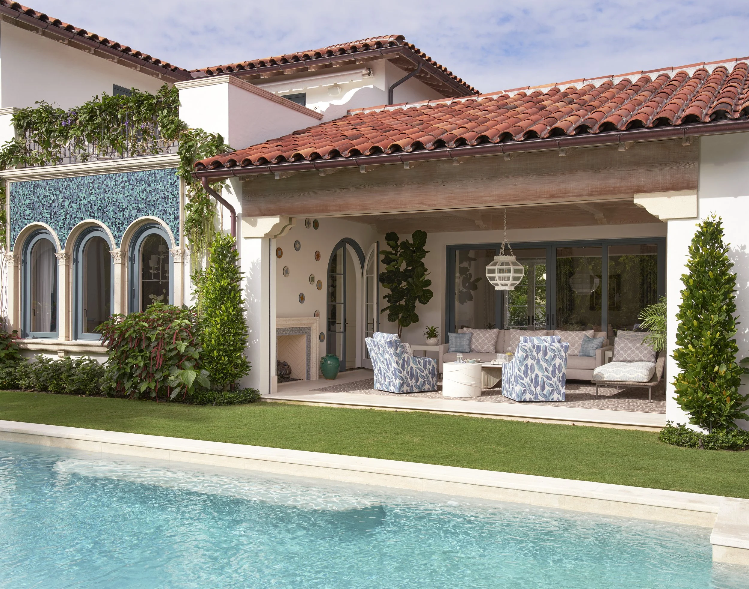 mediterranean style pool backyard with terracotta roof vine covered cabana white lounge chairs palm tree outdoor oasis