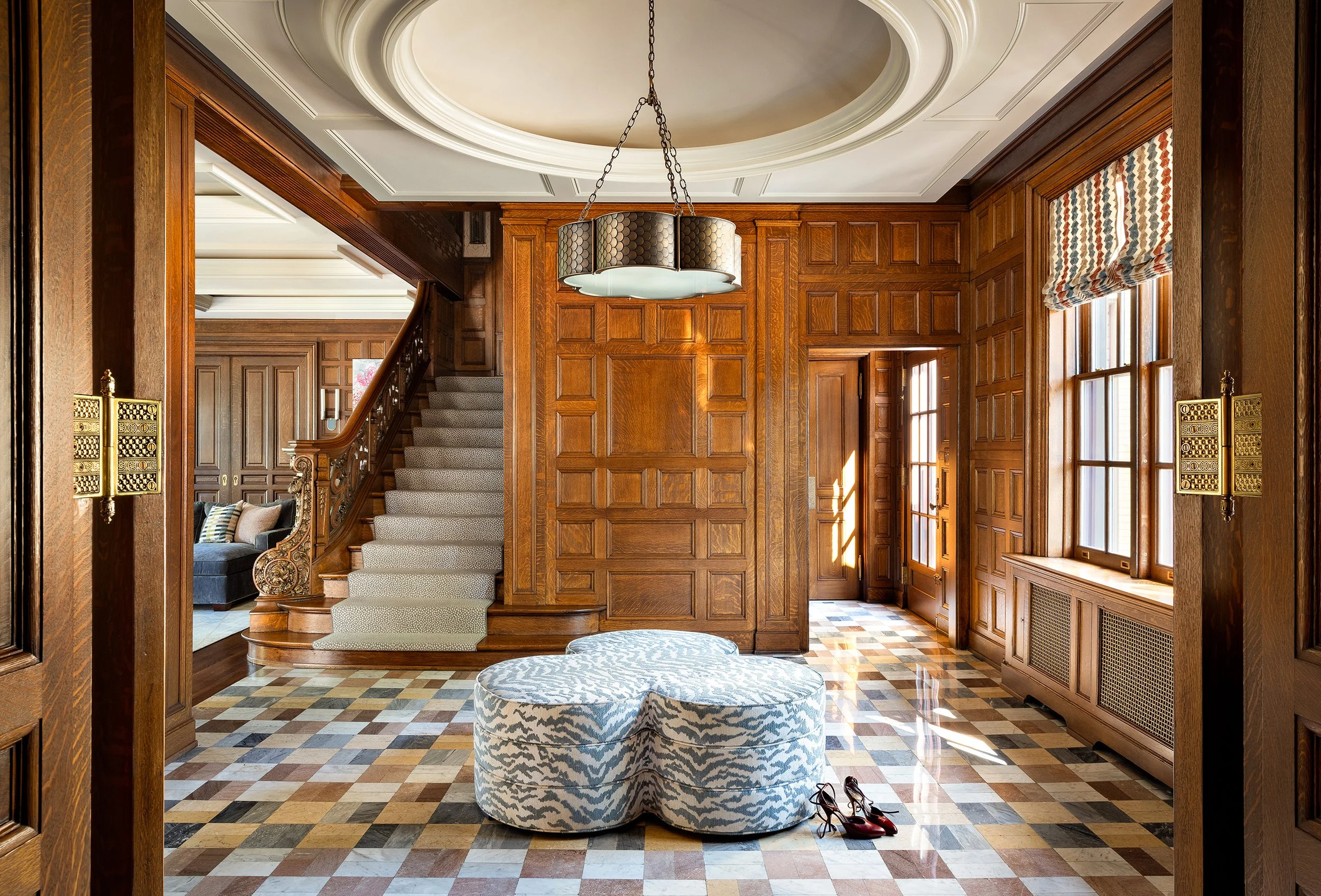 grand entry with marble floors and centerpiece clover ottoman with chandelier