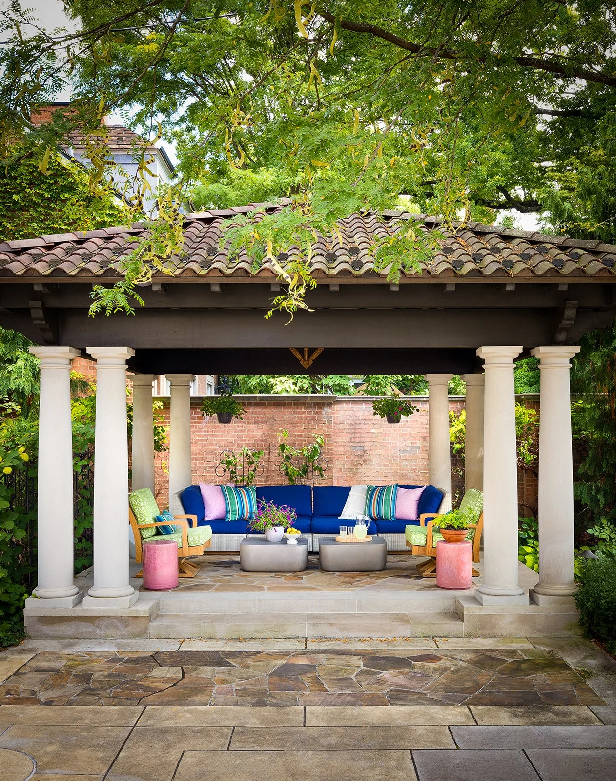 outdoor covered patio with colorful blue sofa green lounge chairs and end tables 
