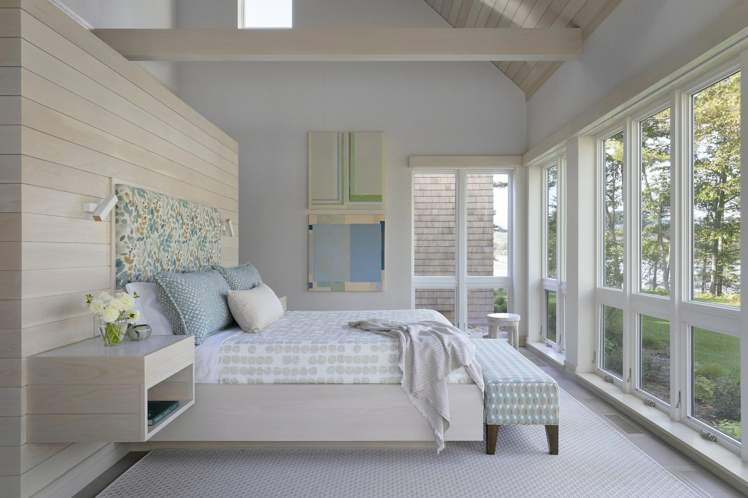 modern bedroom with built in headboard floating nightstands and bench 