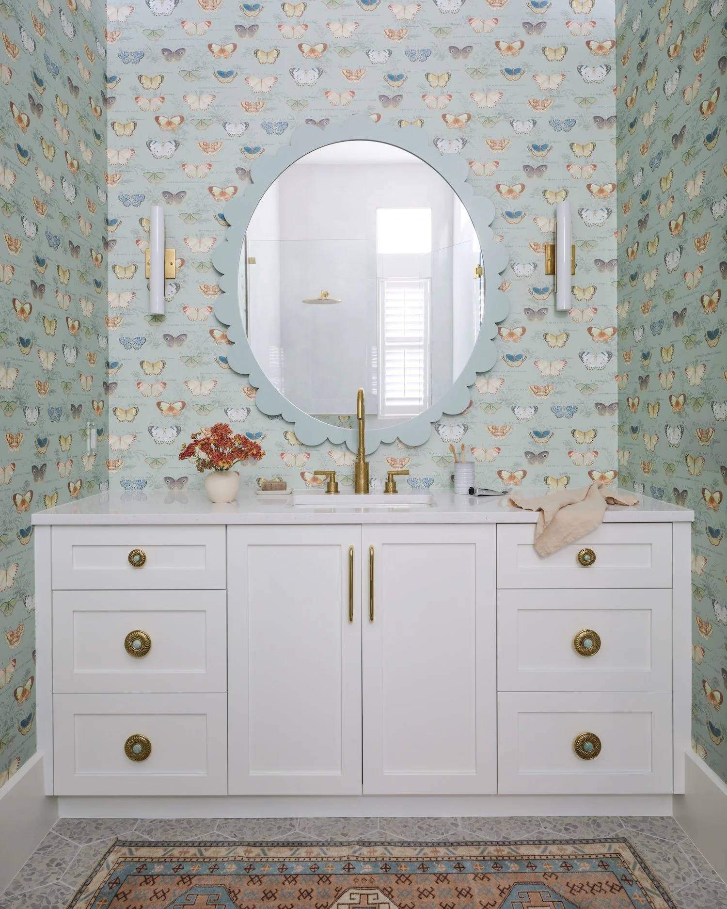 34-butterfly-wallpaper-bathroom-scalloped-mirror-white-vanity-gold-fixtures-colorful-rug-playful-designjpg.jpg