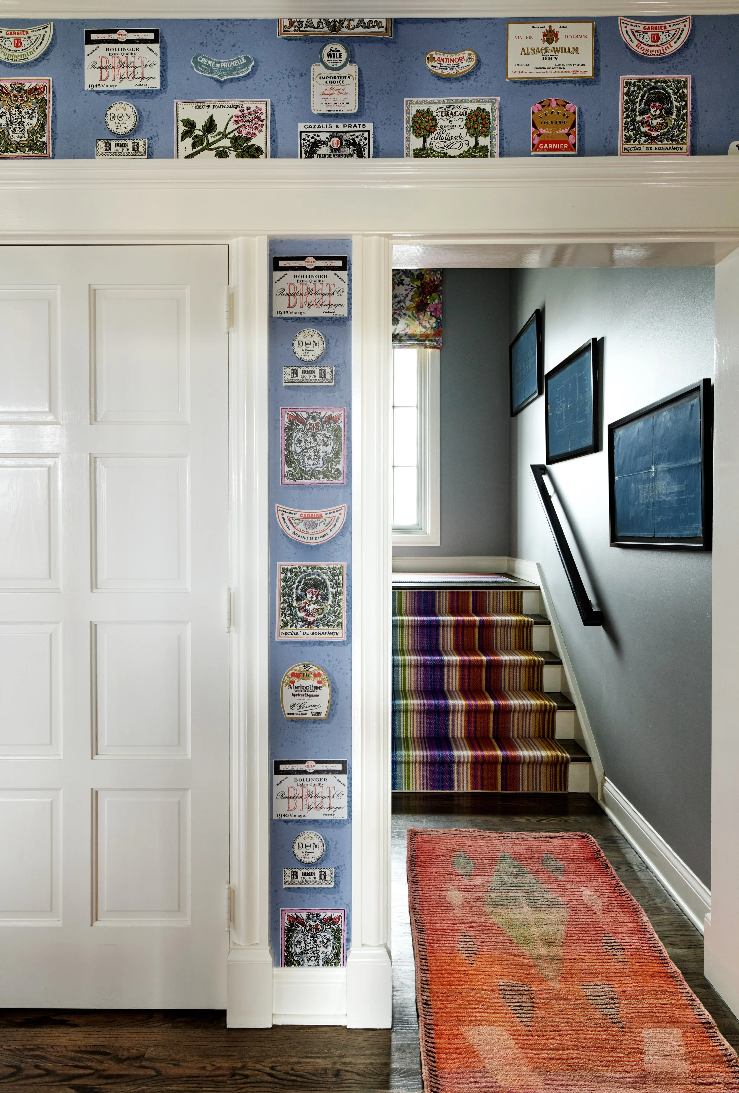 Angle into hallway with fun wallpaper and vintage runner rug.