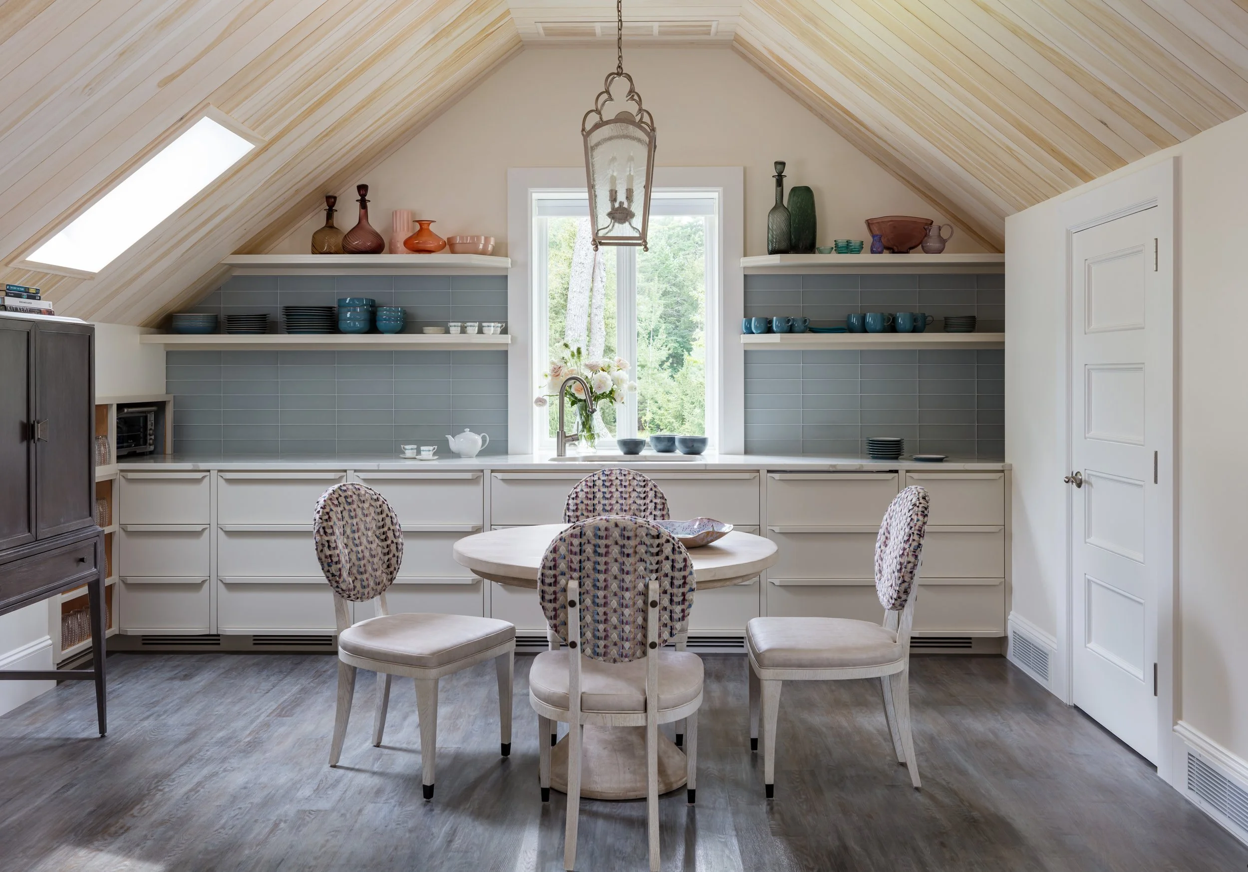 cozy-kitchen-with-white-cabinets-blue-tiles-round-table-patterned-chairs-interior-design-inspiration.jpg