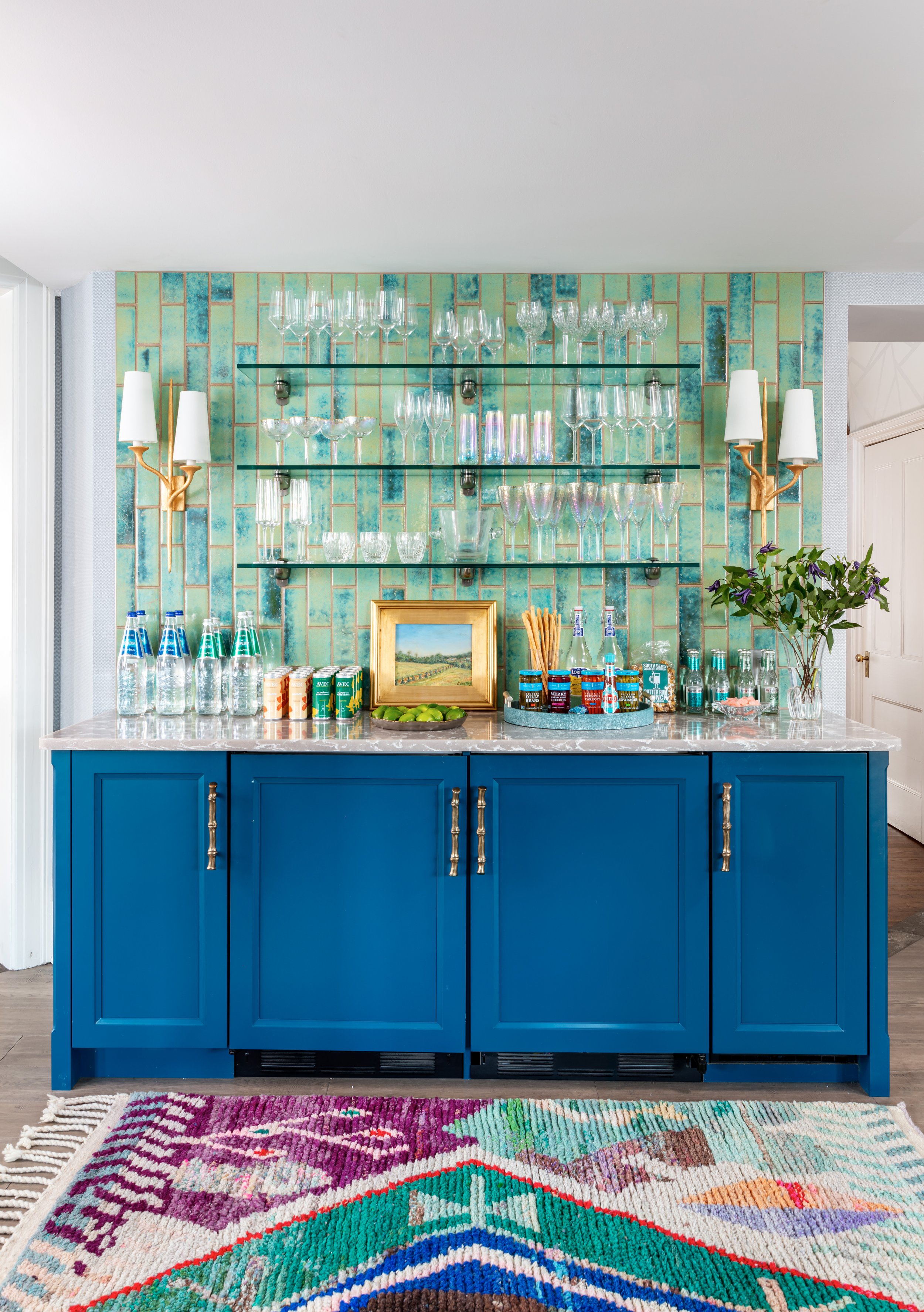 modern bar design with blue cabinets and stacked green tile and glass shelves