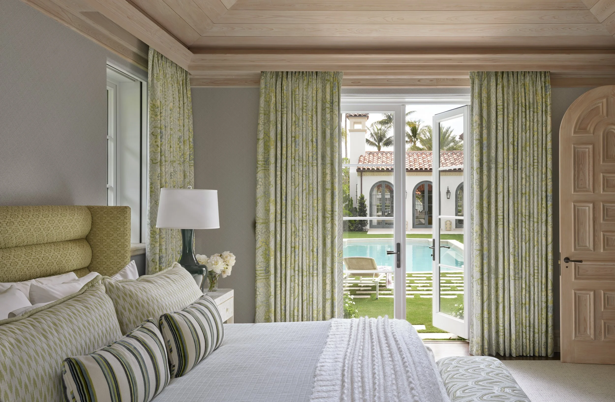 bedroom design with green curtains pool view elegant interior decor modern home inspiration stylish bedding french doors opening to outdoor lounge space
