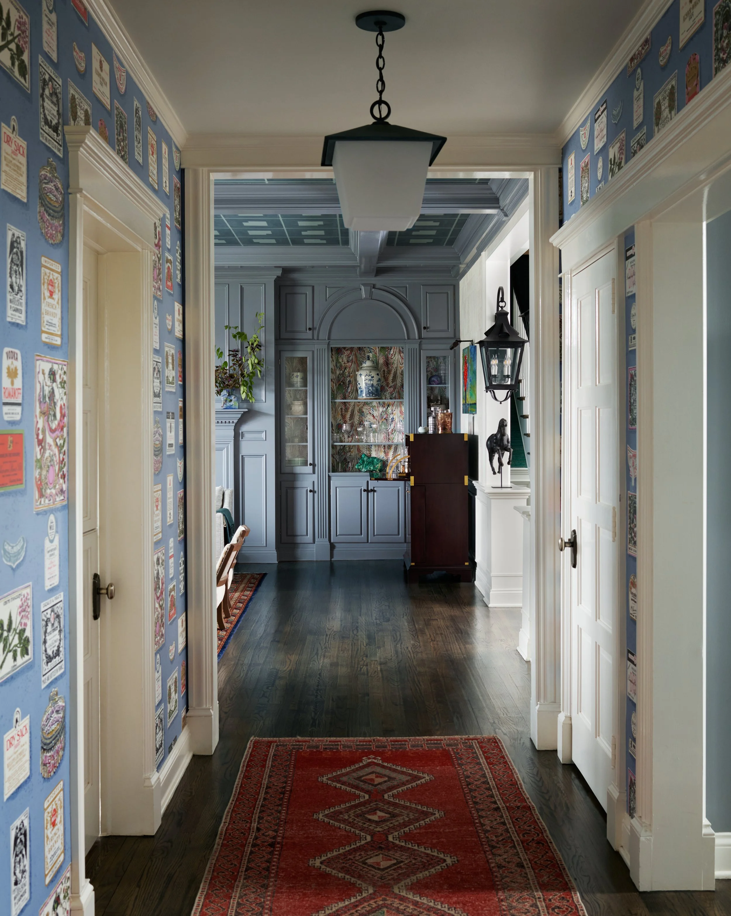 Fun wallpapered hallway with pendant and vintage rug runner. 