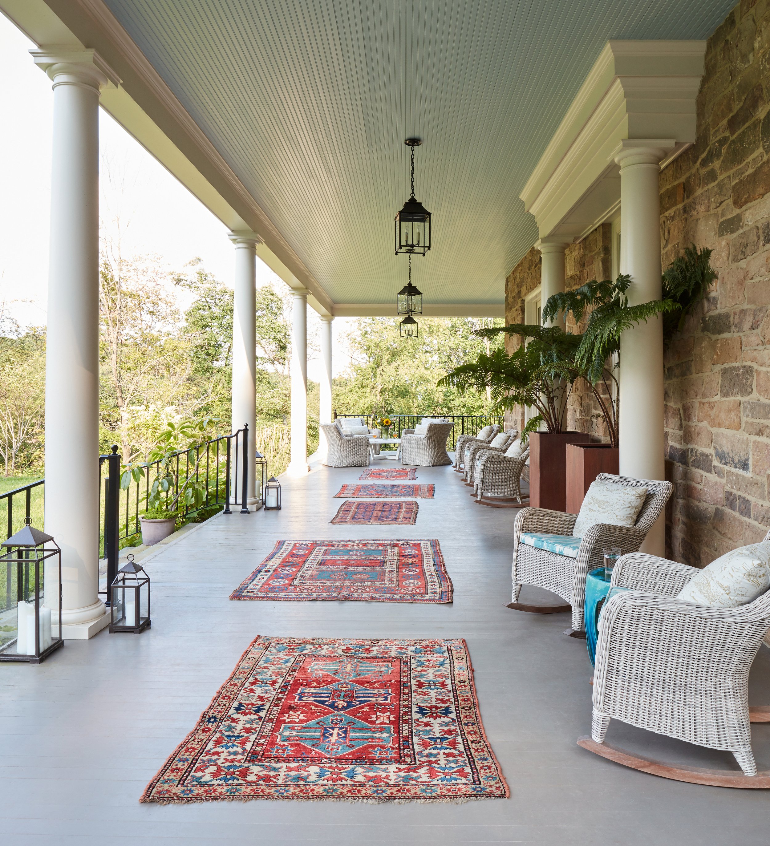 elegant-covered-porch-design-with-wicker-seating-patterned-rugs-stone-pillars-outdoor-interior-design-inspiration.jpg