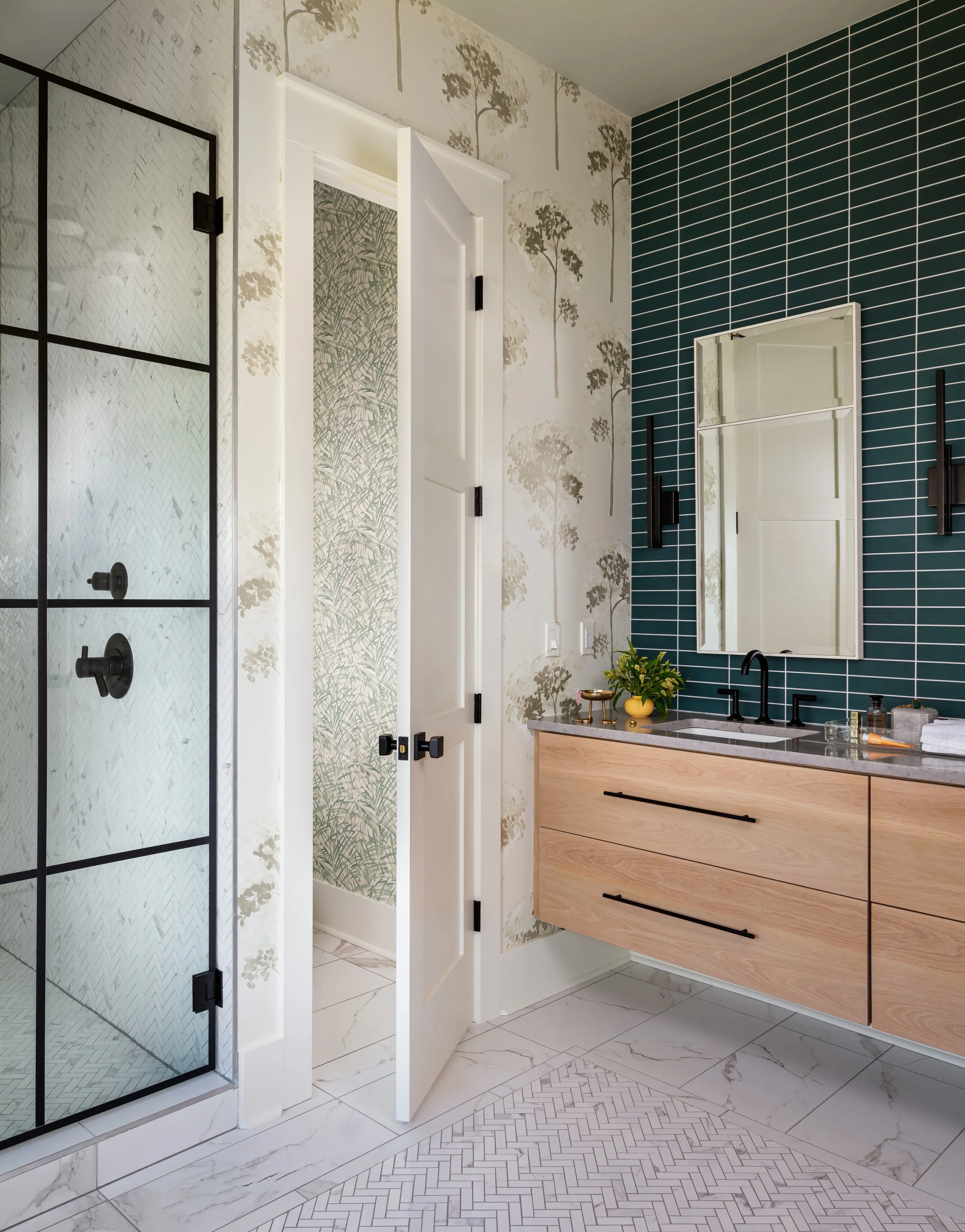 modern bathroom with floating vanity, teal tile accent wall, black fixtures, marble countertop, and walk in shower