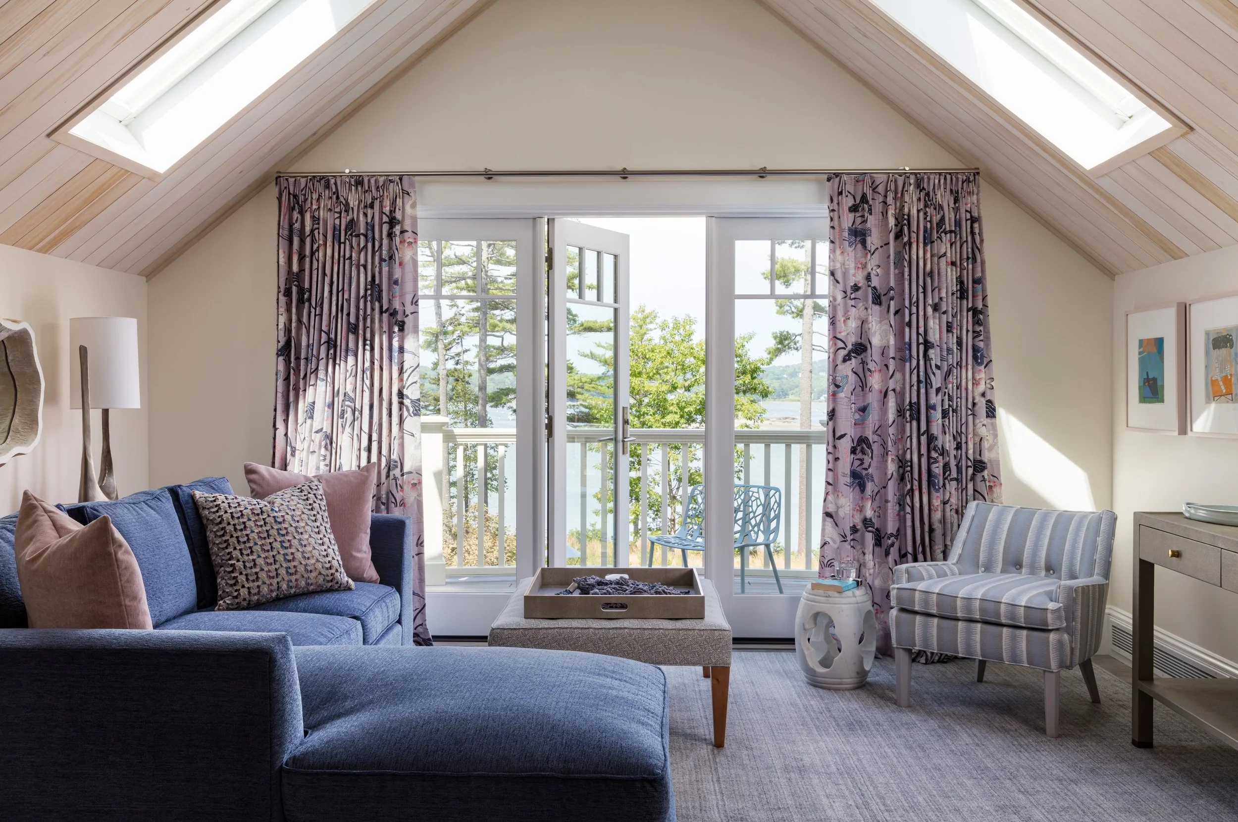 living-room-with-blue-sofa-pink-patterned-pillows-floral-curtains-white-french-doors-gray-striped-chair-and-rustic-coffee-table-for-elegant-interior-design-inspiration.jpg