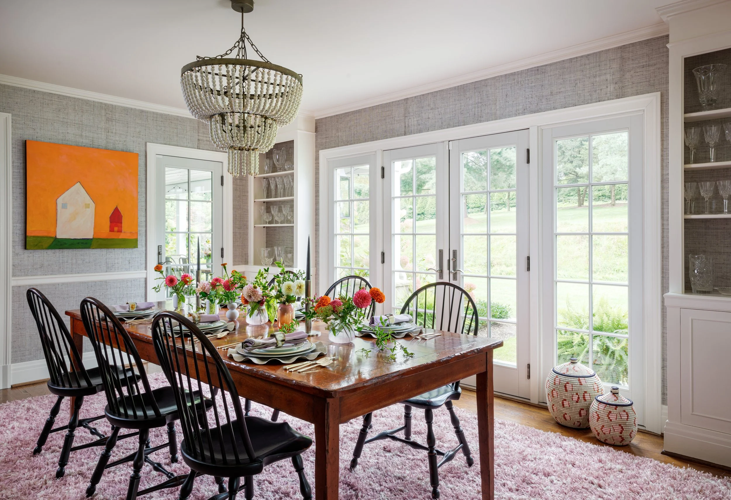 farmhouse inspired dining room with textured wallpaper large wood table chairs and white beaded chandelier