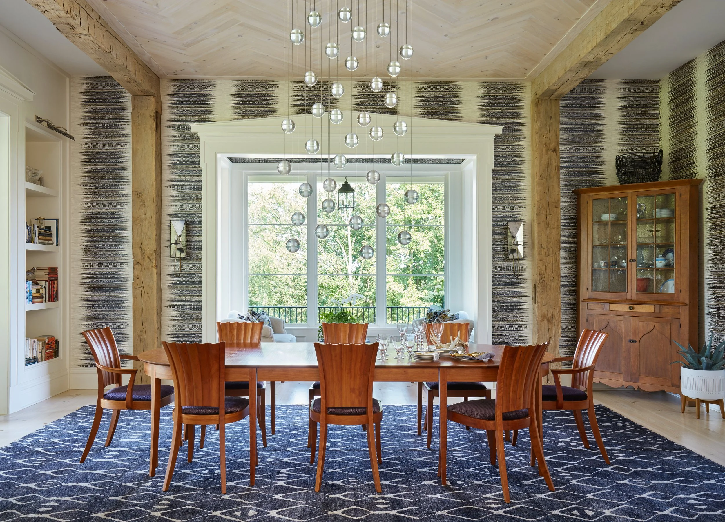 inviting-dining-room-with-wooden-table-chairs-blue-rug-exposed-beams-glass-chandelier-interior-design-inspiration.jpg