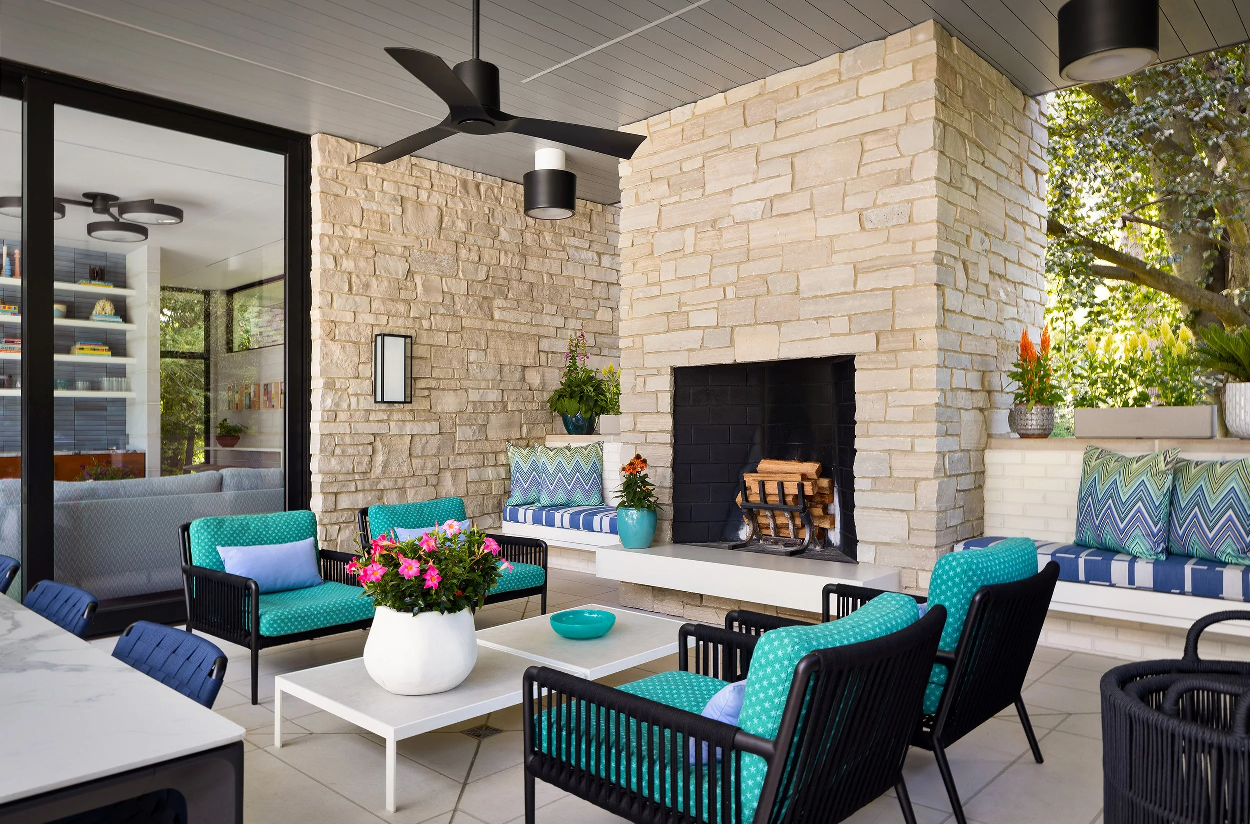 indoor outdoor living comfortable seating area with lounge chairs built in bench seating stone fireplace