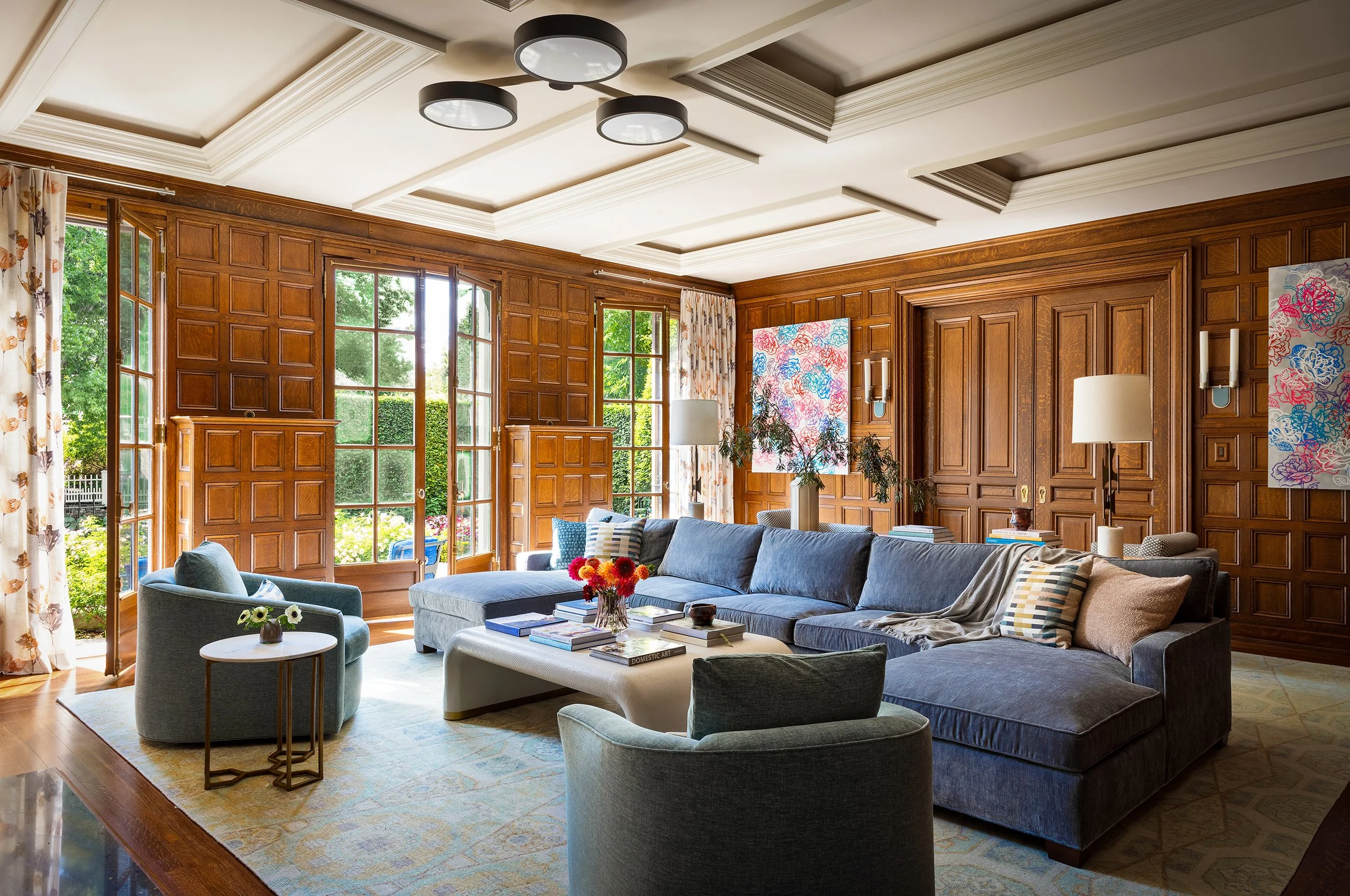 traditional family room design made modern with blue sectional and lounge chair seating