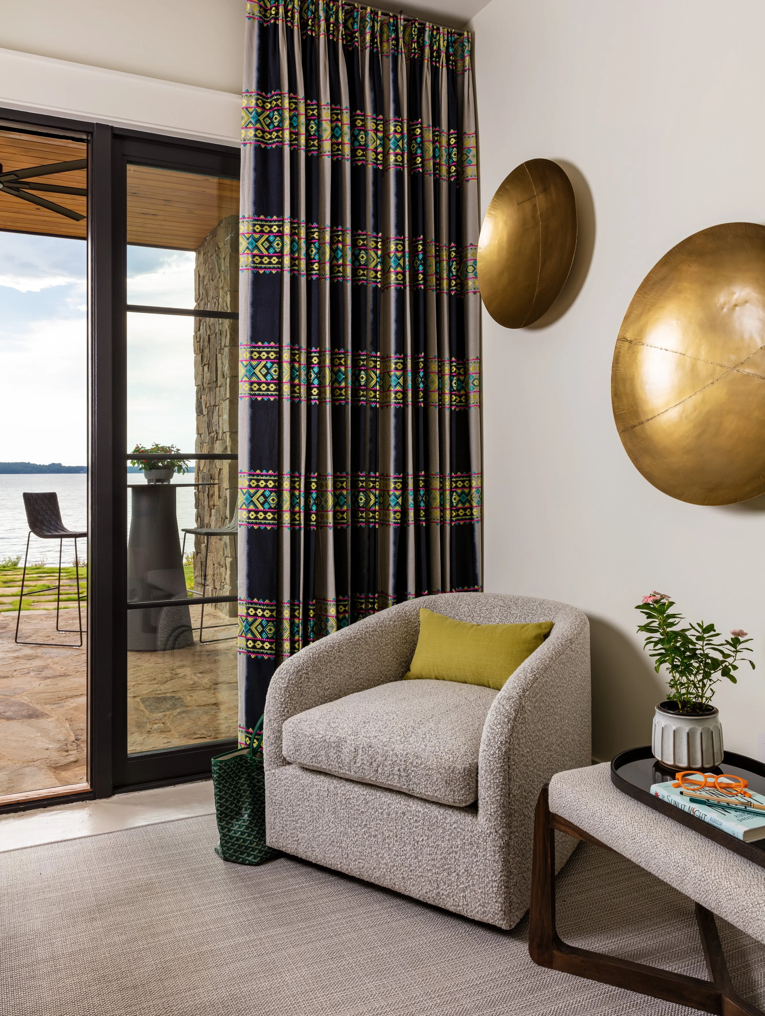 guest room with colorful plaid curtains and swivel chair and patio for cozy interior design inspiration