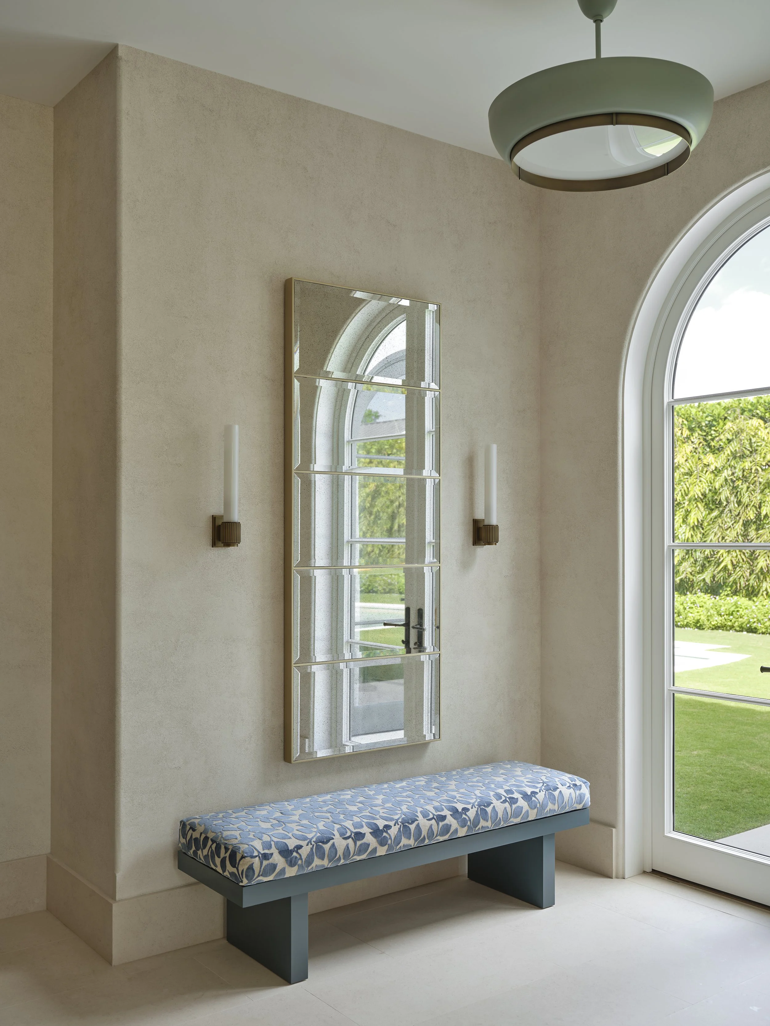 entryway with blue floral bench mirrored window sconces arch light modern interior