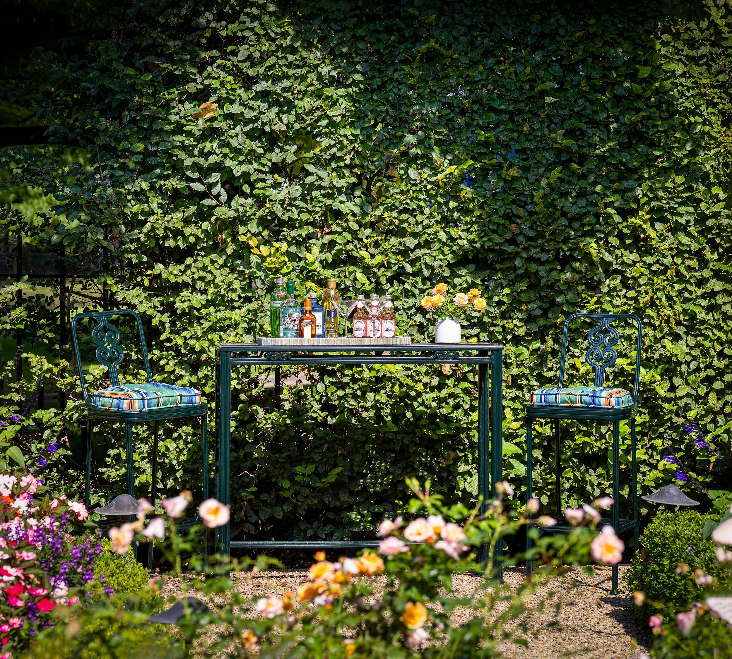 outdoor bar cart and stools in garden setting