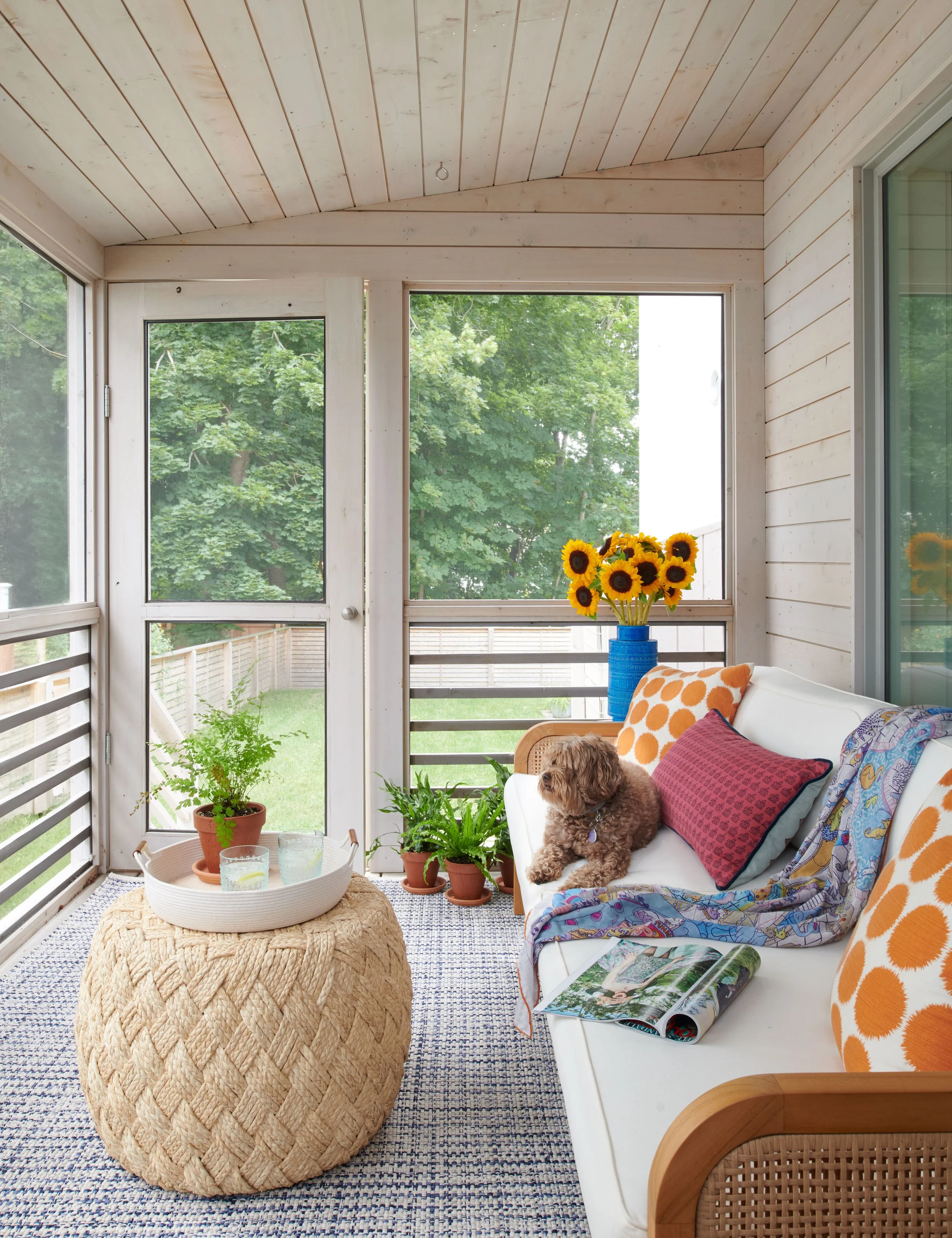 inviting-layout-for-screened-porch-with-cozy-sofa-and-ottoman.jpg