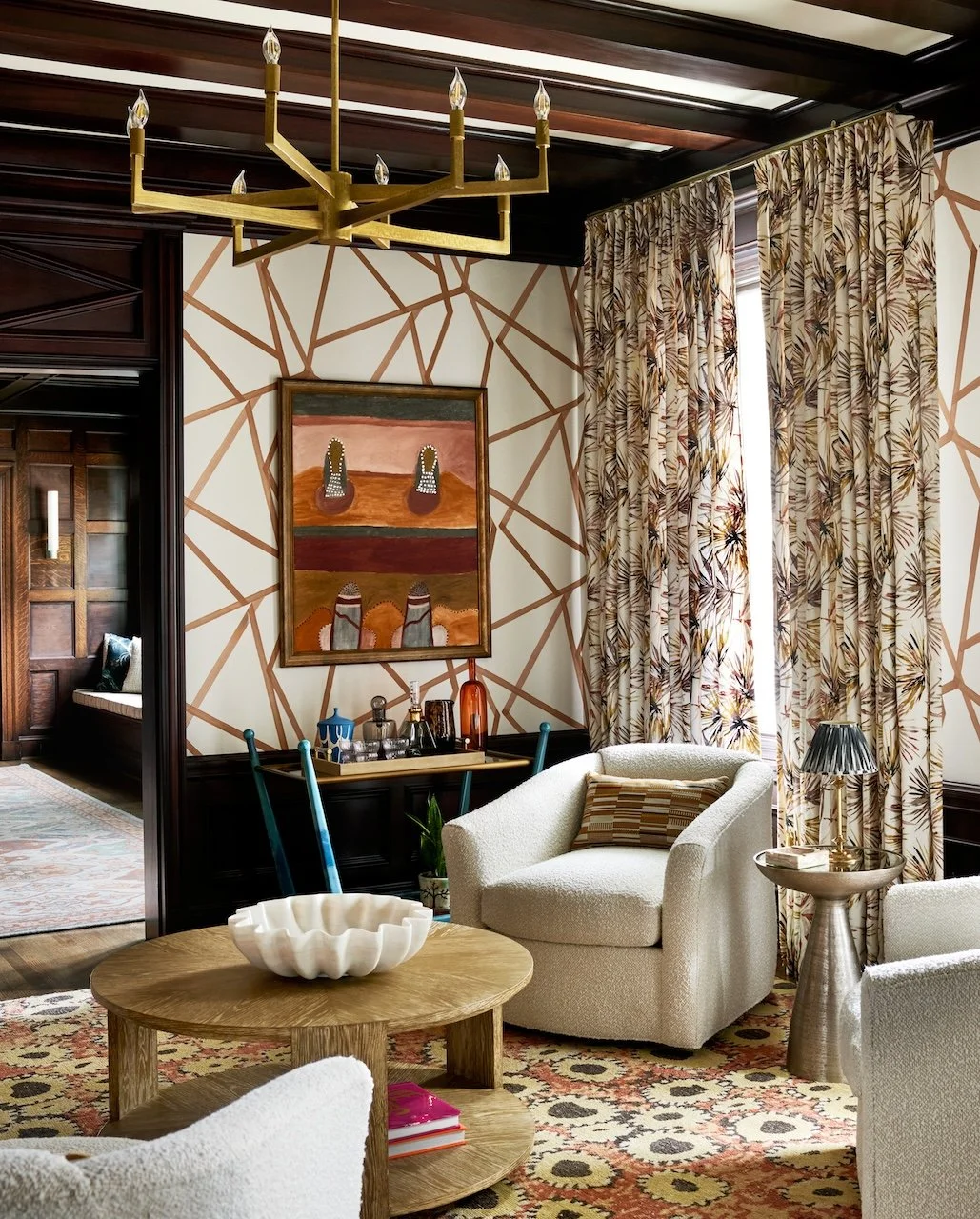 Moody traditional living room beamed ceiling patterned drapes boucle chairs layered rugs 
